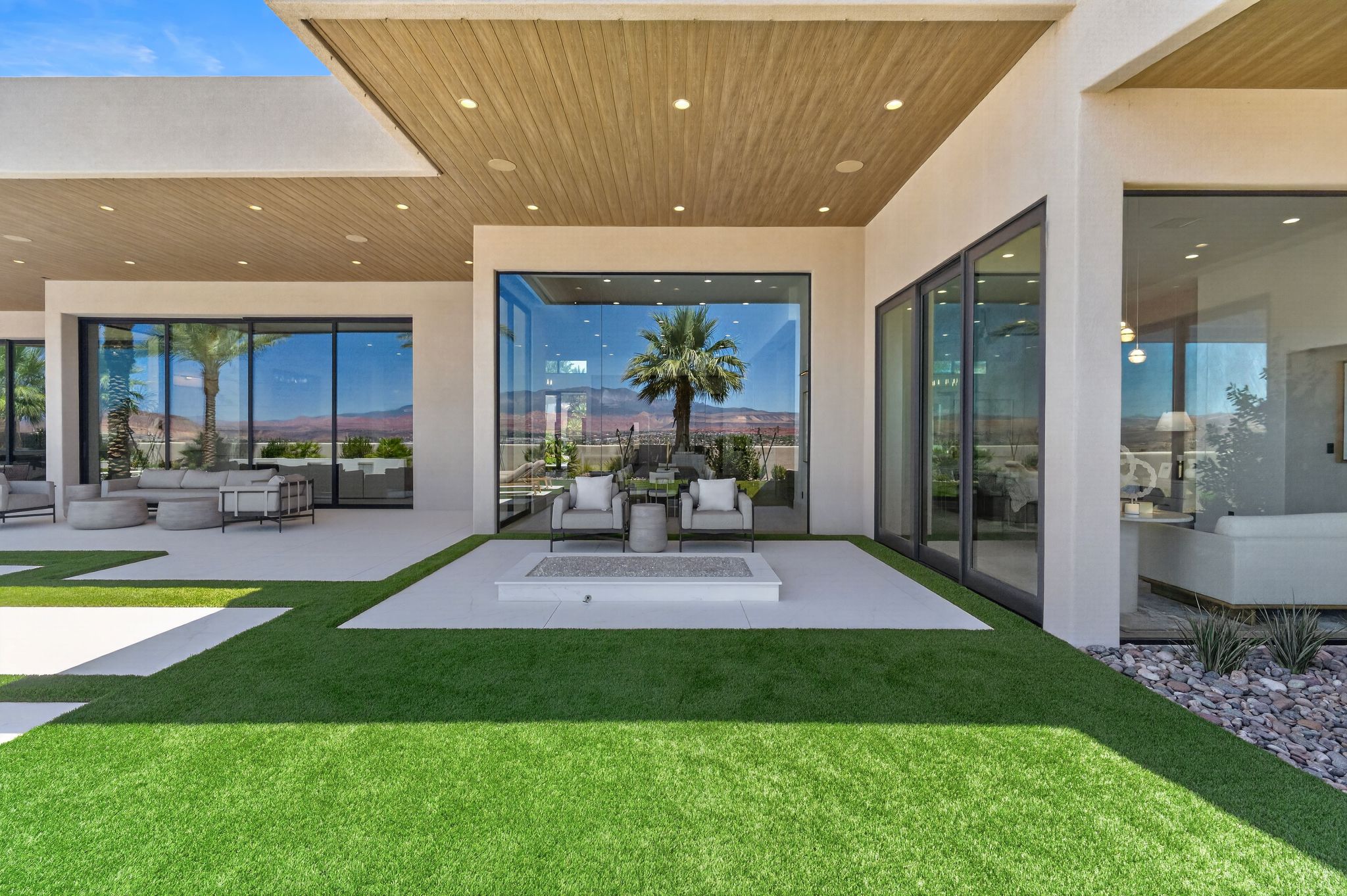 Expansive outdoor living area featuring multiple paved patios and integrated artificial turf