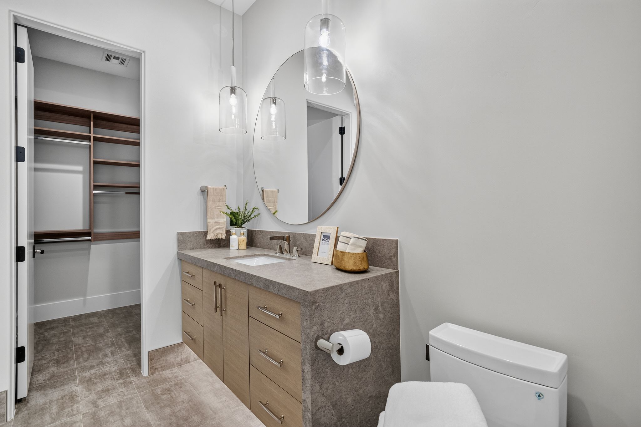 Bathroom vanity with a rectangular sink, dual pendant lighting, and a circular mirror