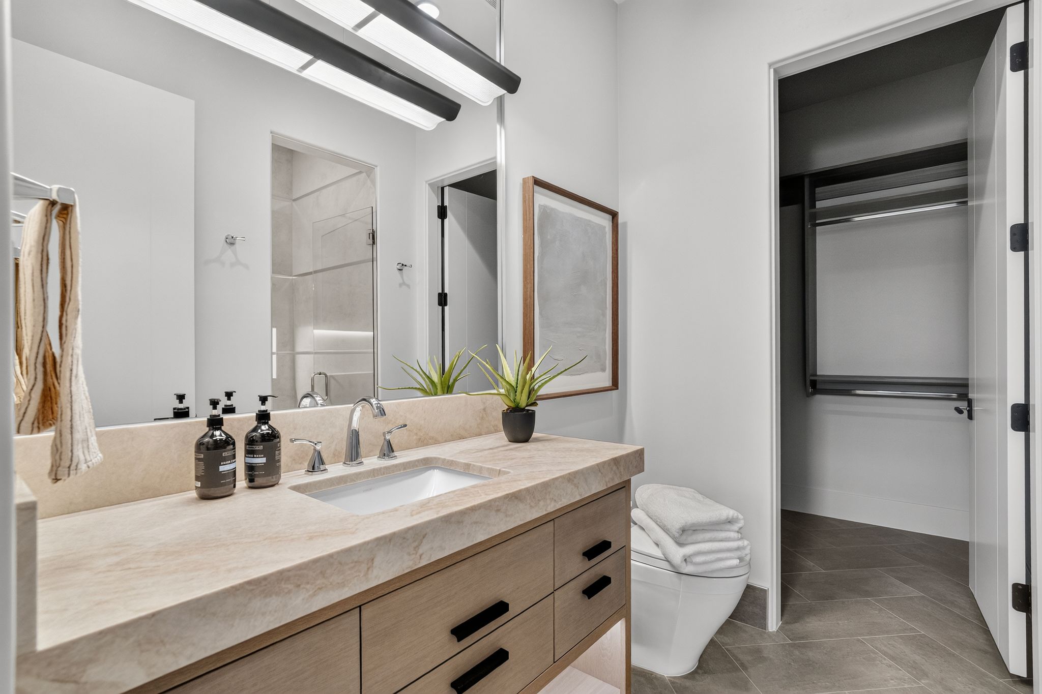 Bathroom vanity featuring a stone countertop, an undermount sink, and a chrome faucet