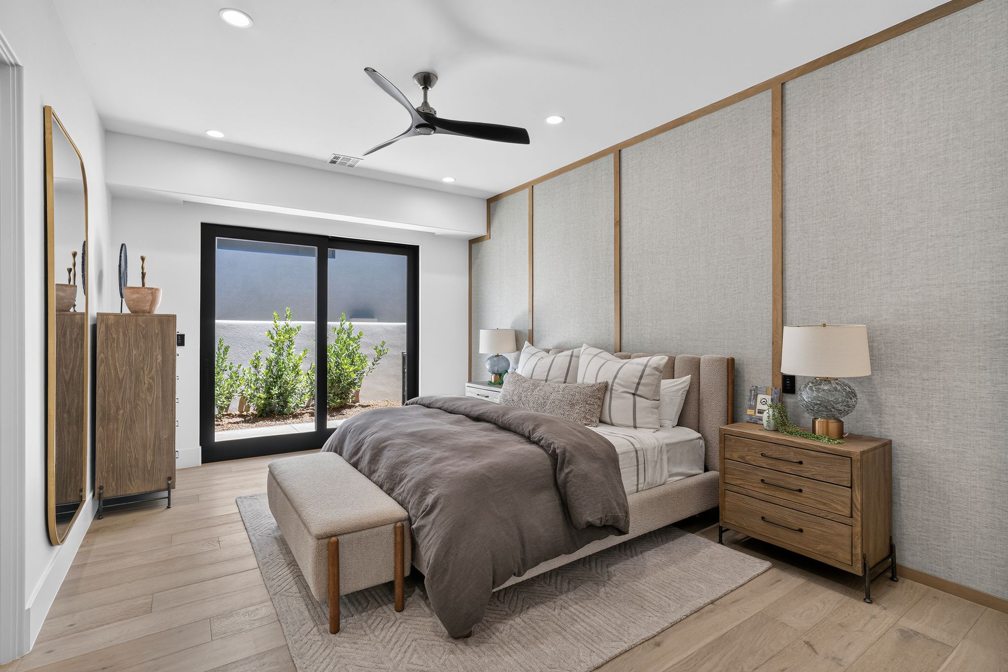 Spacious bedroom featuring wood-finish flooring and a contemporary ceiling fan