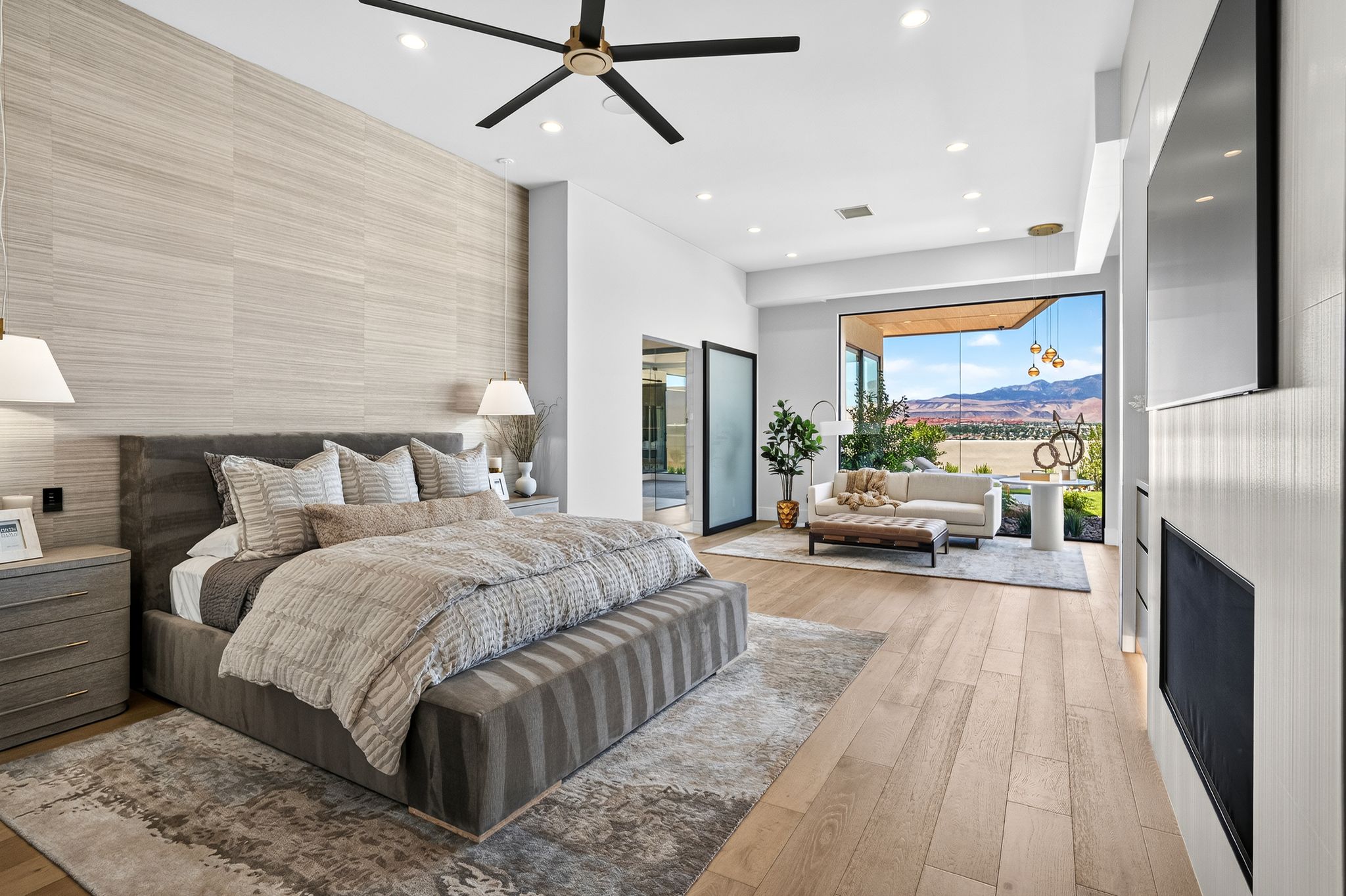 Spacious interior featuring wood-finish flooring, a contemporary ceiling fan, and recessed lighting