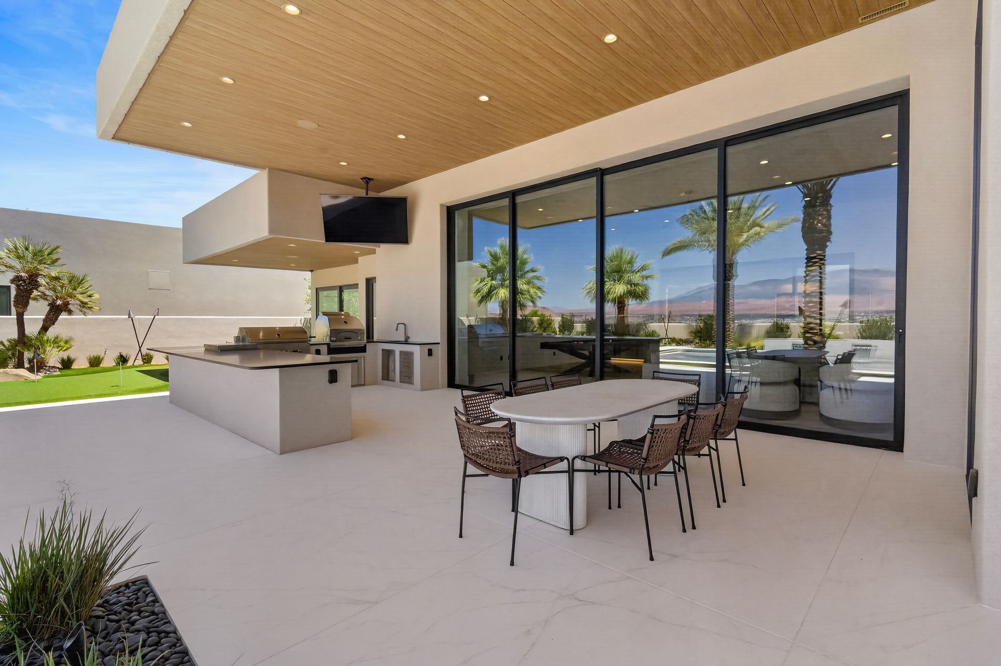 Expansive outdoor living area featuring a wood-finish ceiling, recessed lighting, and large format tile flooring
