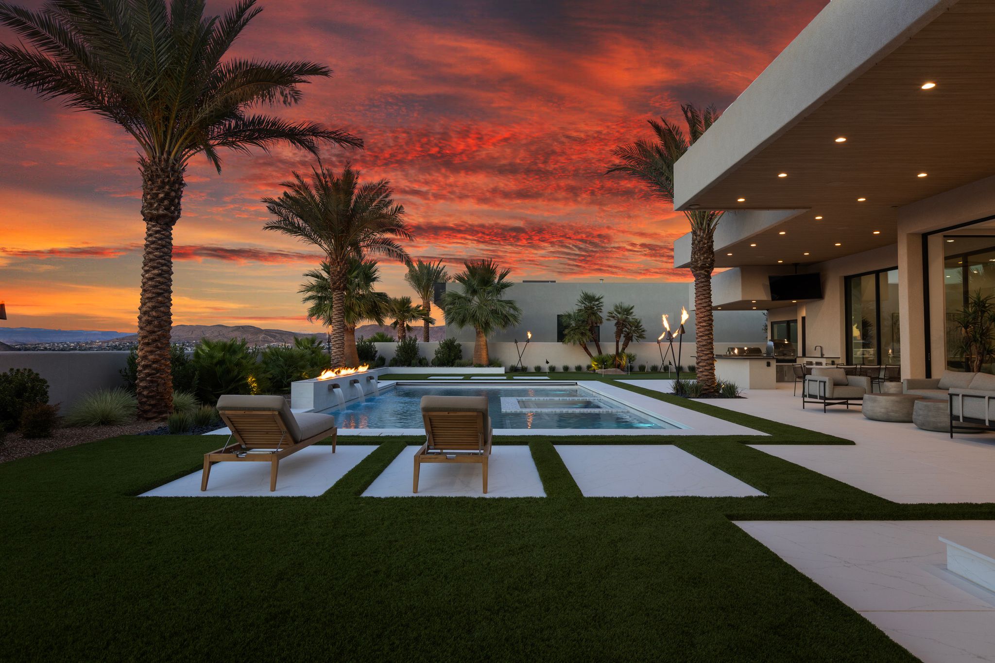 Expansive backyard featuring a rectangular swimming pool with integrated spa and fire features
