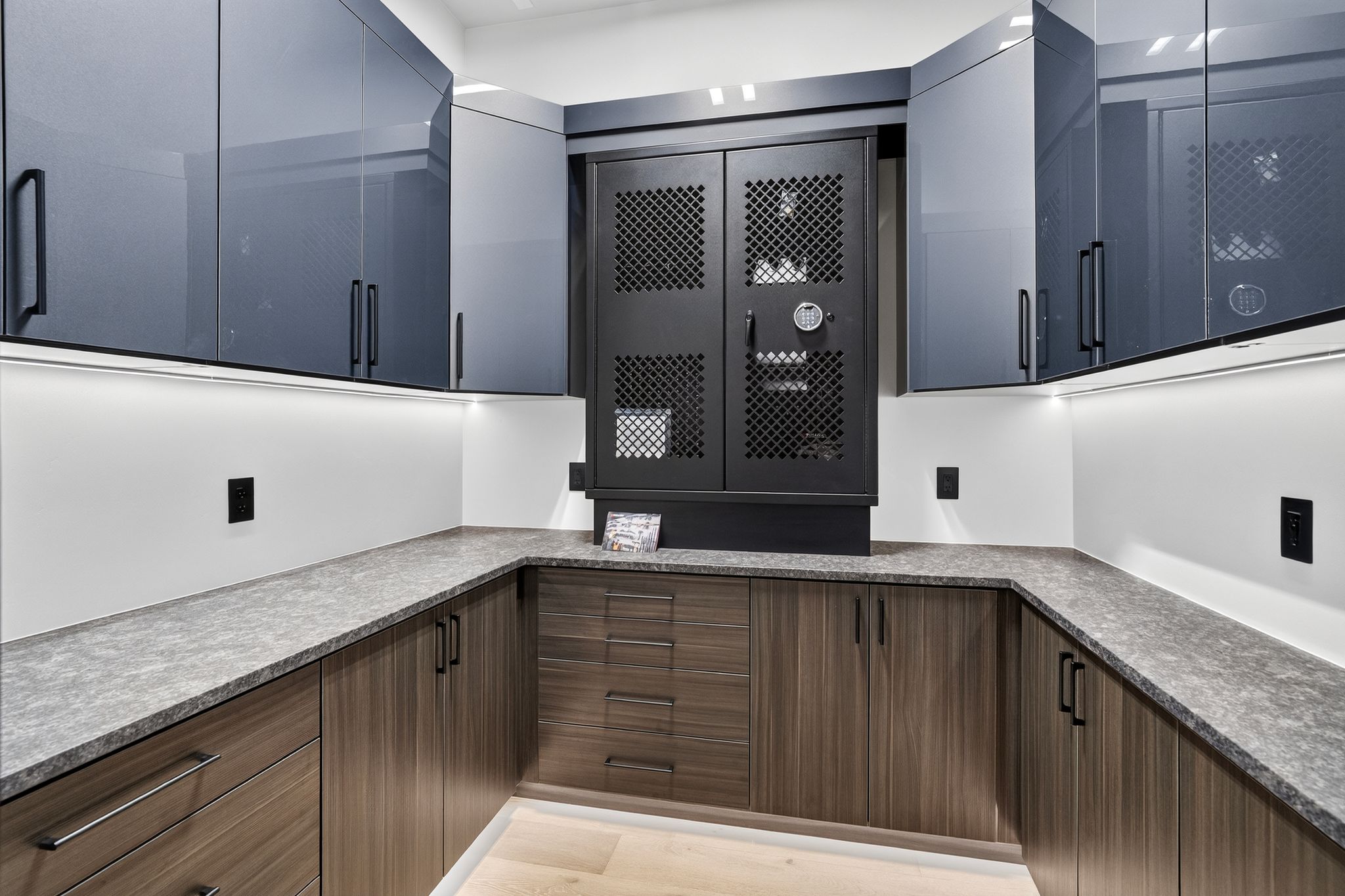 Custom storage area featuring U-shaped countertops, dark wood-finish lower cabinetry, and grey-toned upper cabinets with black hardware
