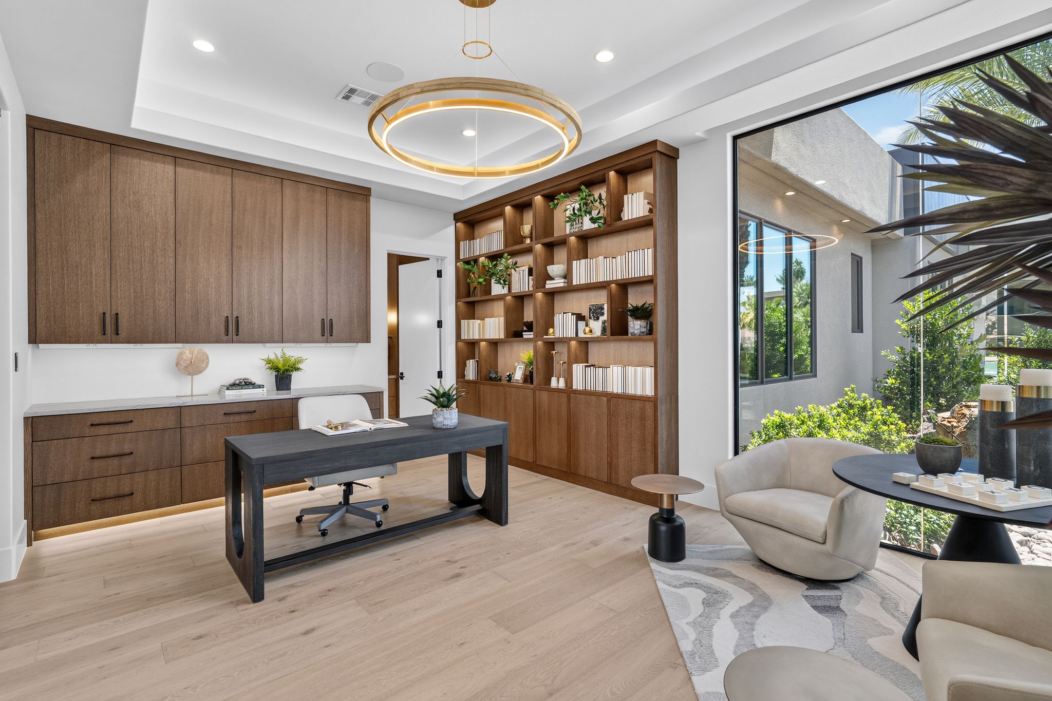 Dedicated workspace featuring built-in wood-finish cabinetry, integrated shelving, a recessed ceiling, and large floor-to-ceiling windows