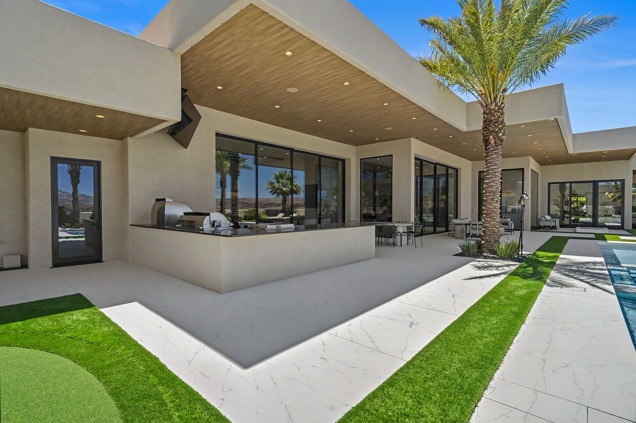 Expansive outdoor living area featuring a covered patio with recessed lighting and wood-finish ceiling