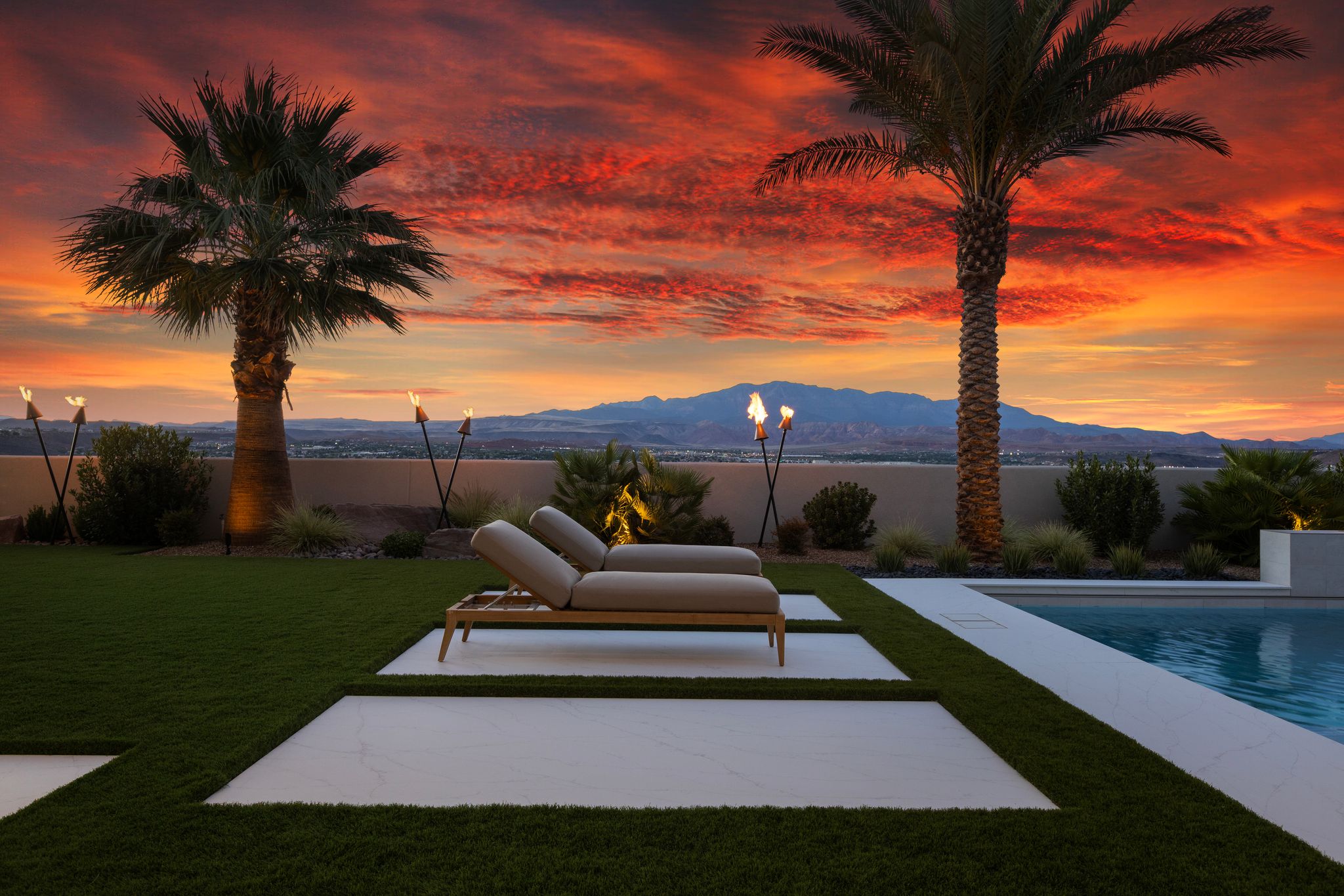 Modern outdoor living space featuring a swimming pool, artificial turf, and integrated patio pavers