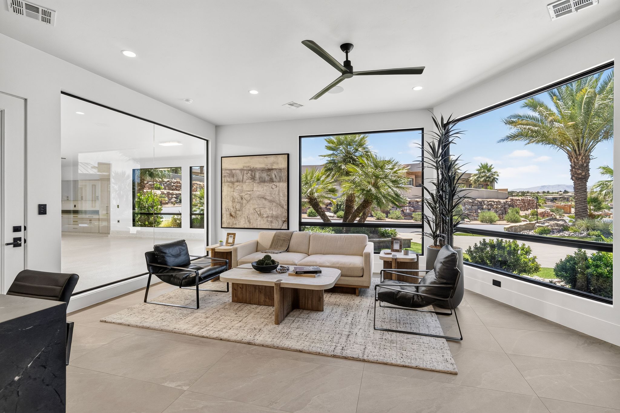 Expansive living area featuring large format tile flooring and a contemporary ceiling fan