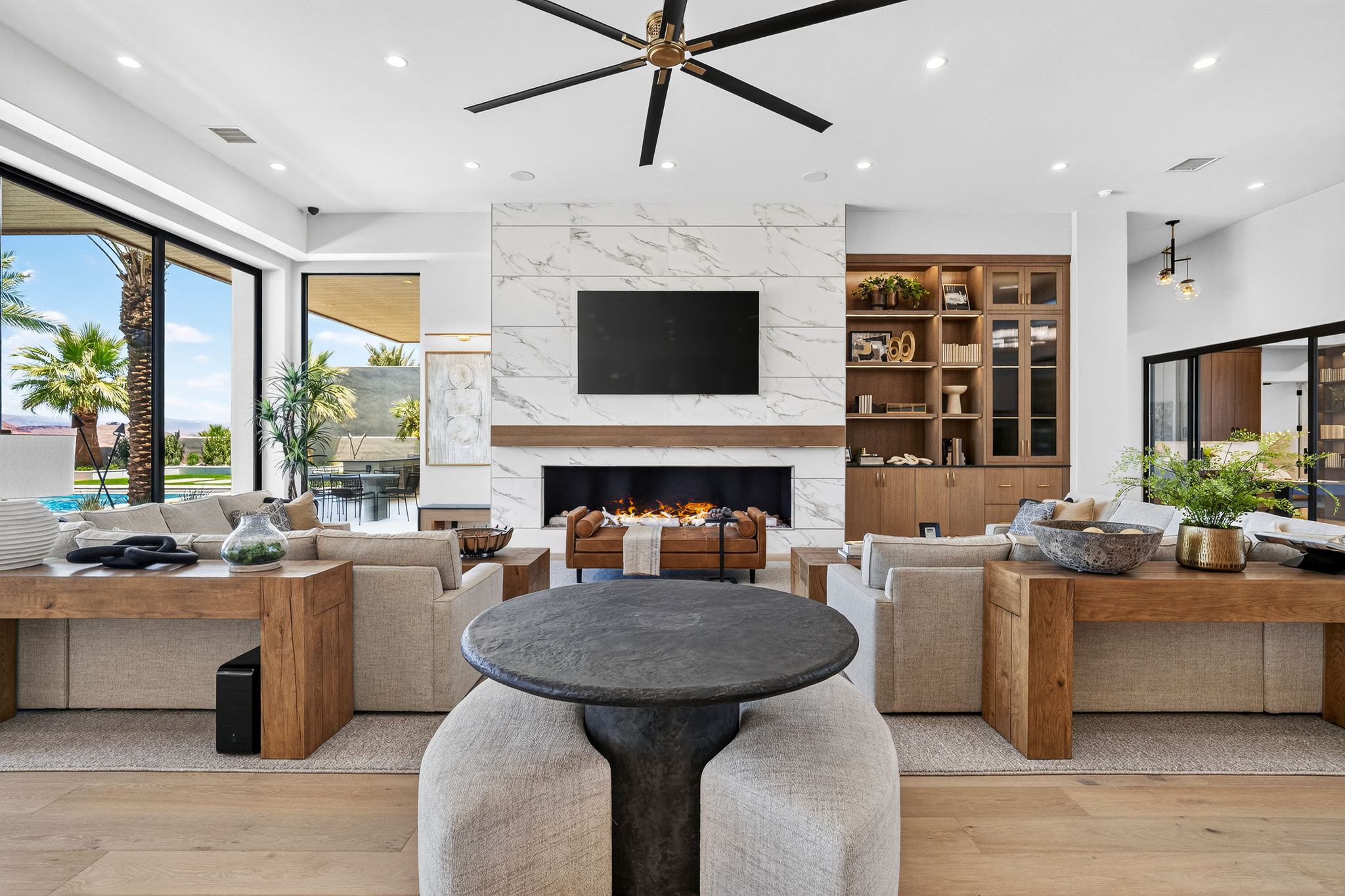 Spacious living area featuring a marble-clad fireplace, integrated media center, and custom built-in cabinetry