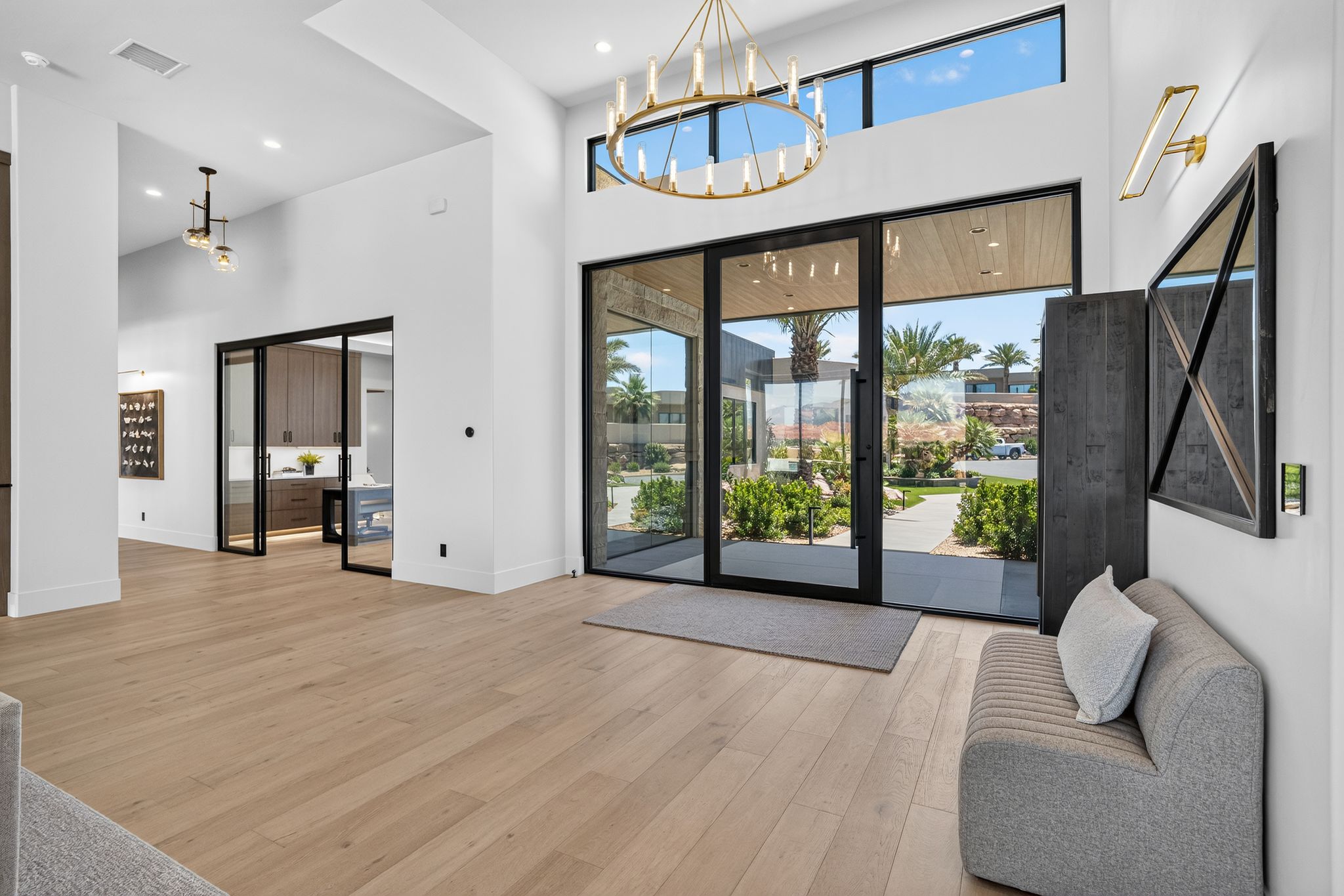Grand entry featuring a tall ceiling, a large chandelier, and expansive glass doors