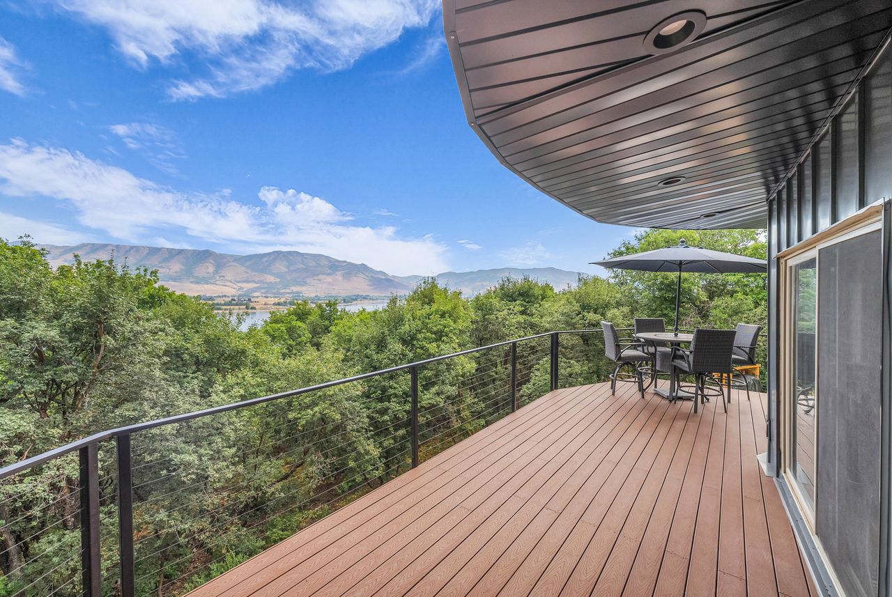 Expansive outdoor deck featuring wood-finish flooring, cable railings, and recessed ceiling lighting