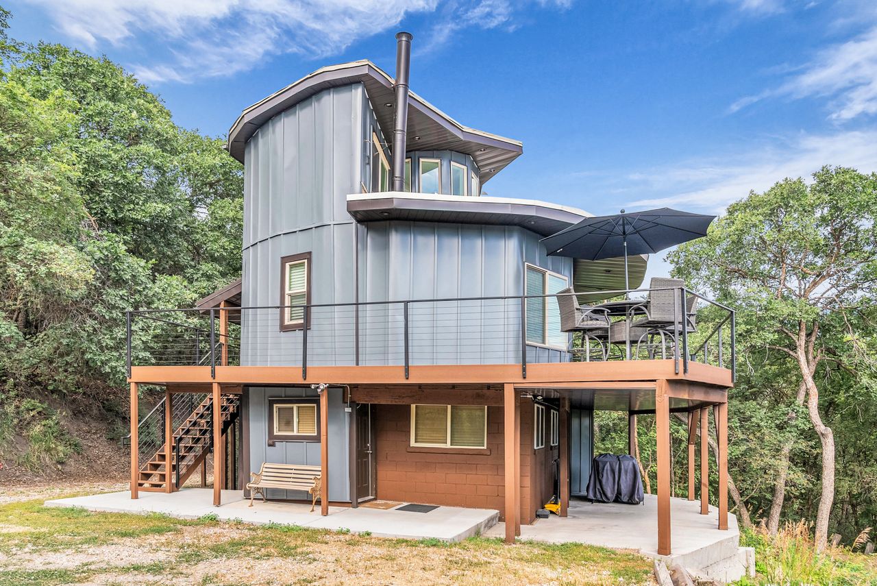 Multi-level residence featuring a unique cylindrical design with horizontal paneling