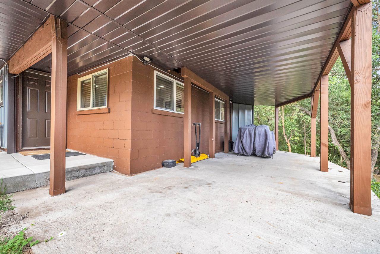 Expansive concrete patio area with a brown corrugated metal ceiling