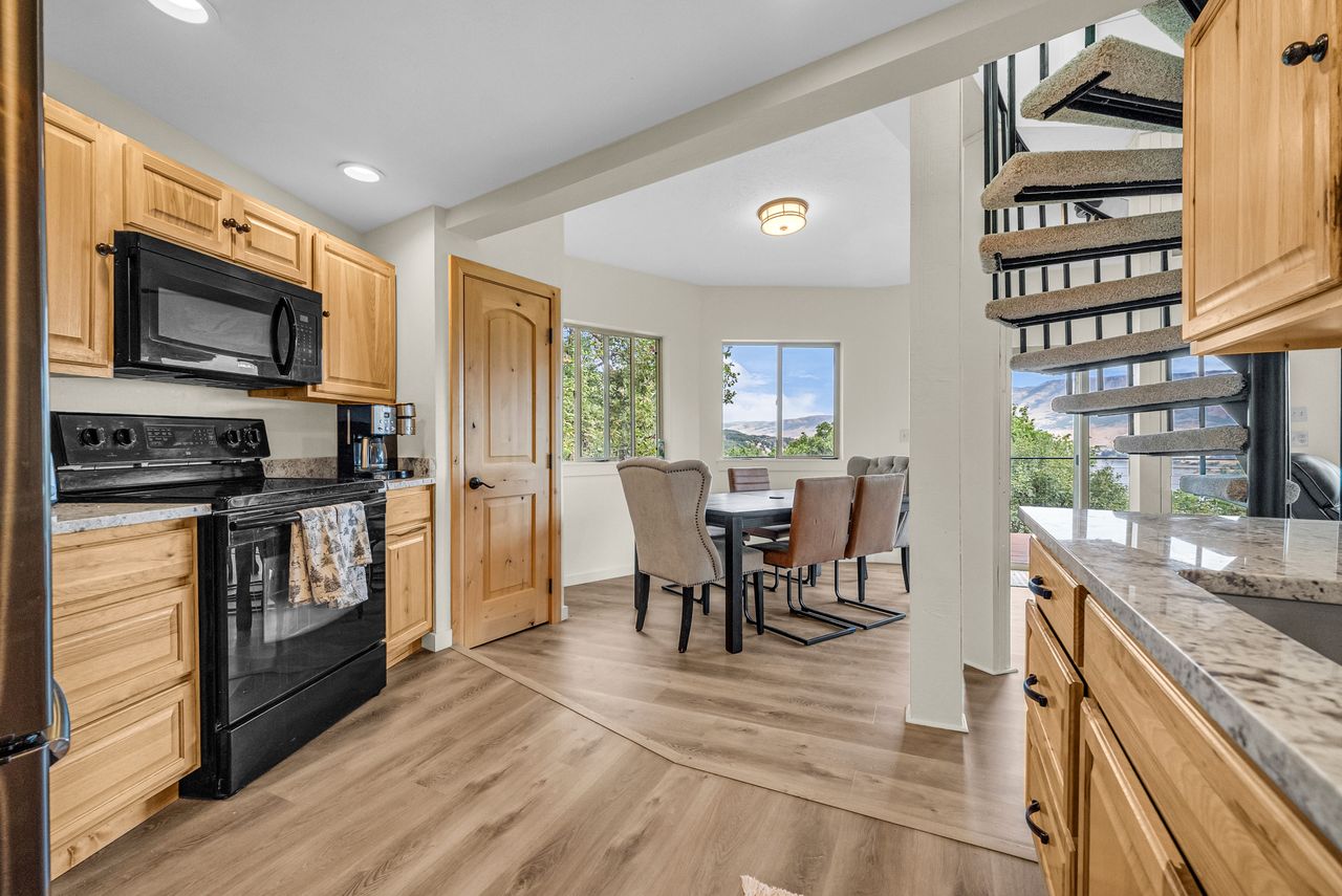 Kitchen featuring wood cabinetry, black appliances, recessed lighting, and light-toned countertops