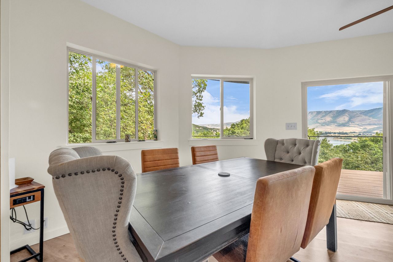 Open-concept room featuring white walls, wood-finish flooring, and a sliding glass door to an exterior deck