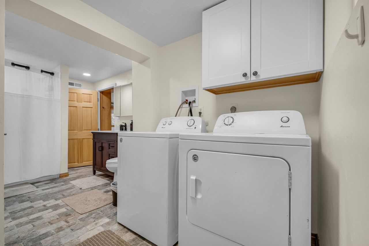 Dedicated laundry area featuring a white upper cabinet and light neutral wall paint