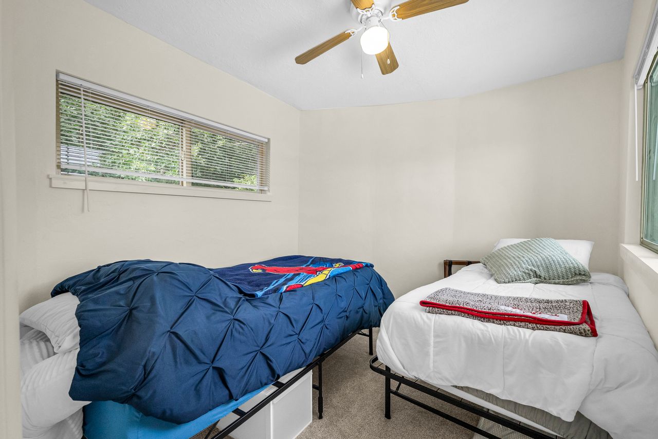 Bedroom featuring neutral wall paint, a ceiling fan with integrated lighting, and carpet flooring