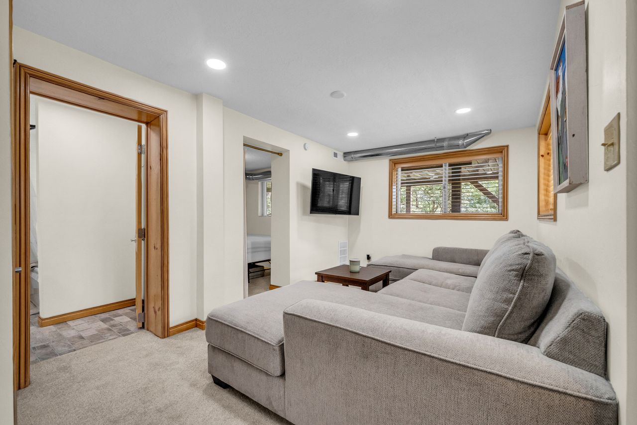 Carpeted room with recessed lighting and a window featuring wood-finish trim and blinds
