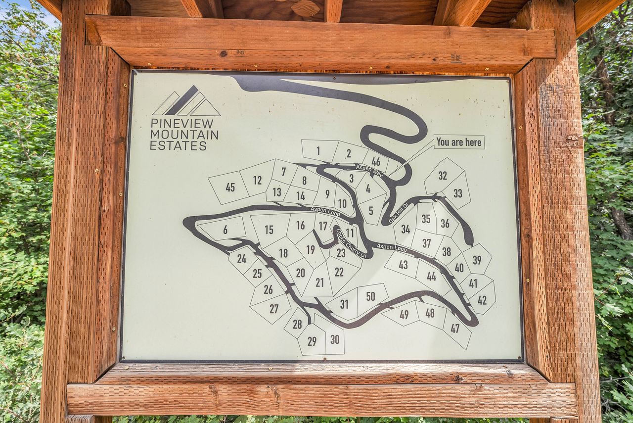Wood-framed information board displaying a community map for Pineview Mountain Estates, featuring individual lot numbers and internal roadways