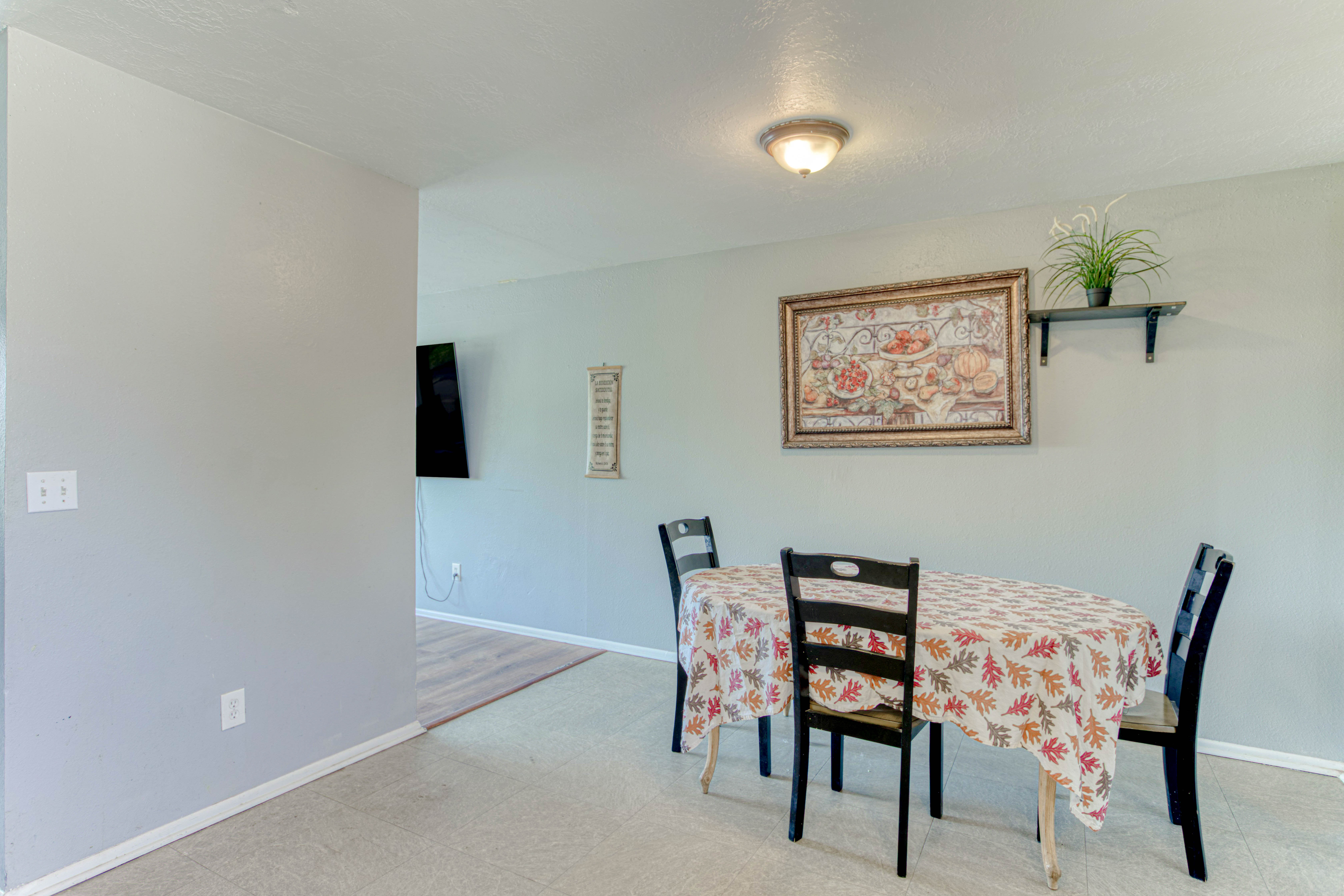 Dining area featuring neutral wall tones, recessed ceiling lighting, and a wall-mounted floating shelf