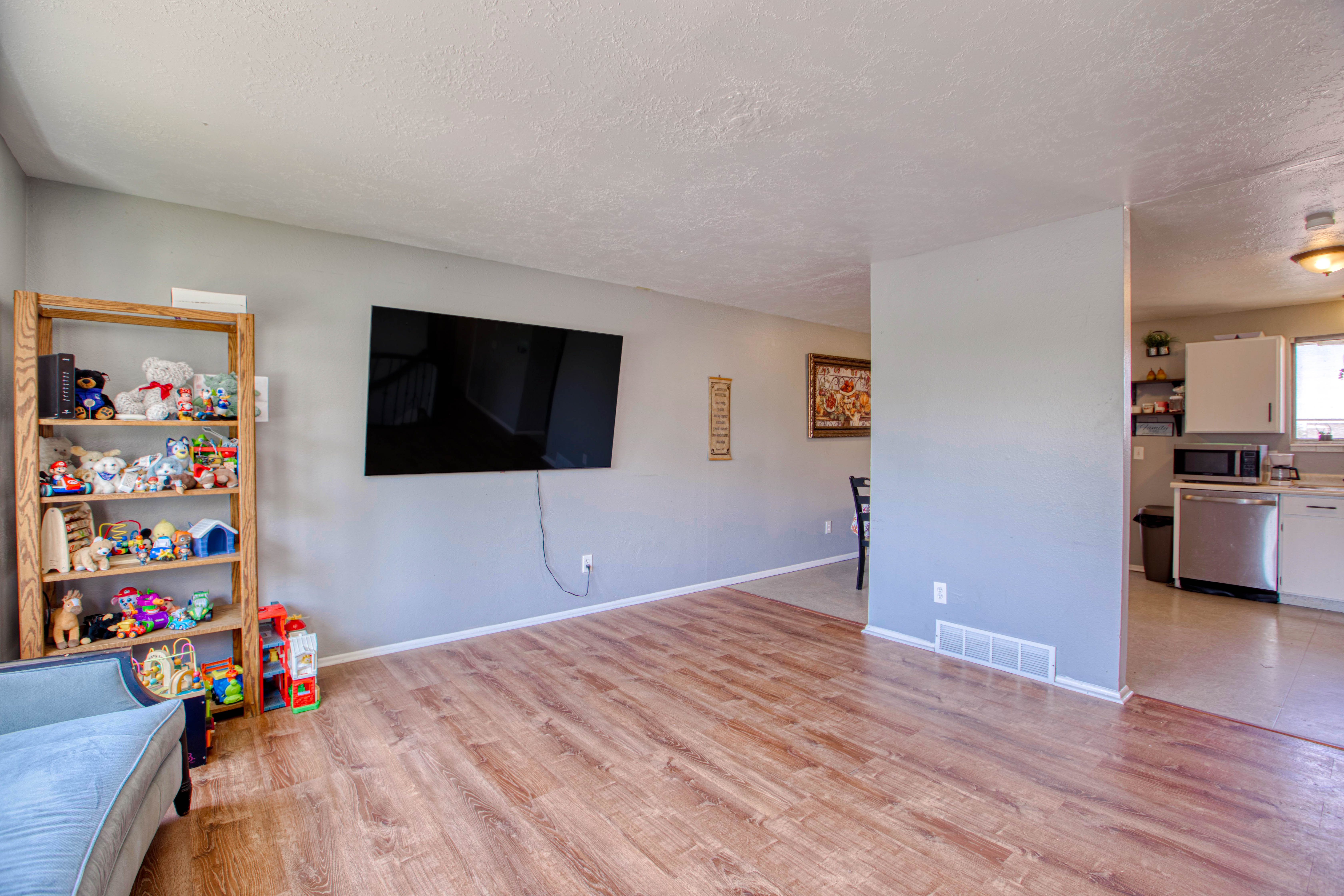 Living area with wood-finish flooring, light gray wall paint, and white baseboards