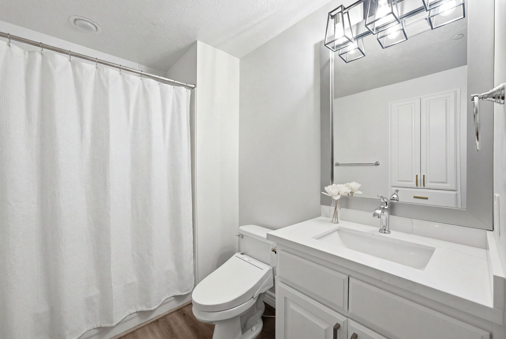 Main bathroom featuring a white vanity with updated sink, fixtures and quartz countertop.