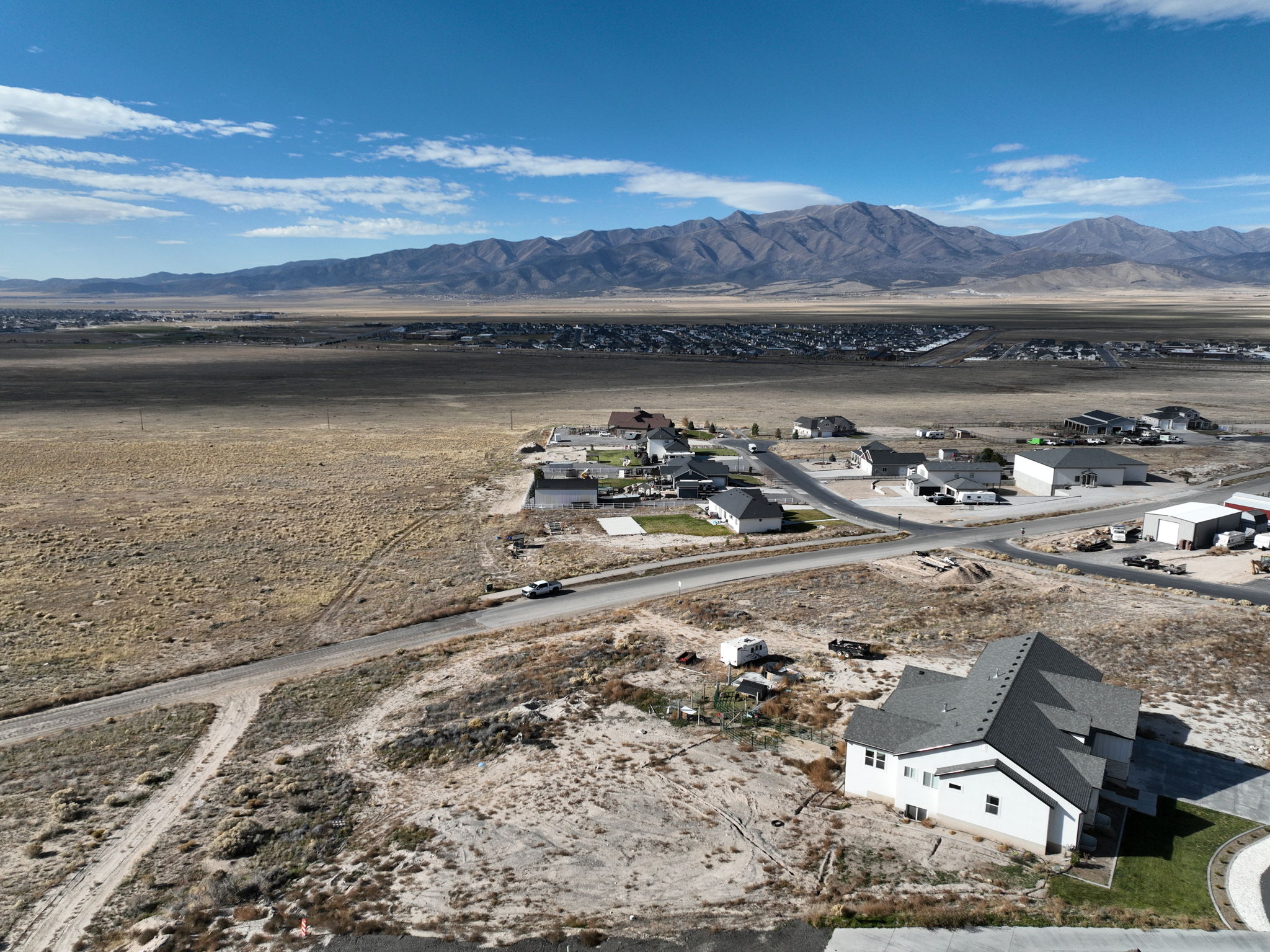 Mountain backdrop with expansive undeveloped land surrounding a residential area featuring new construction