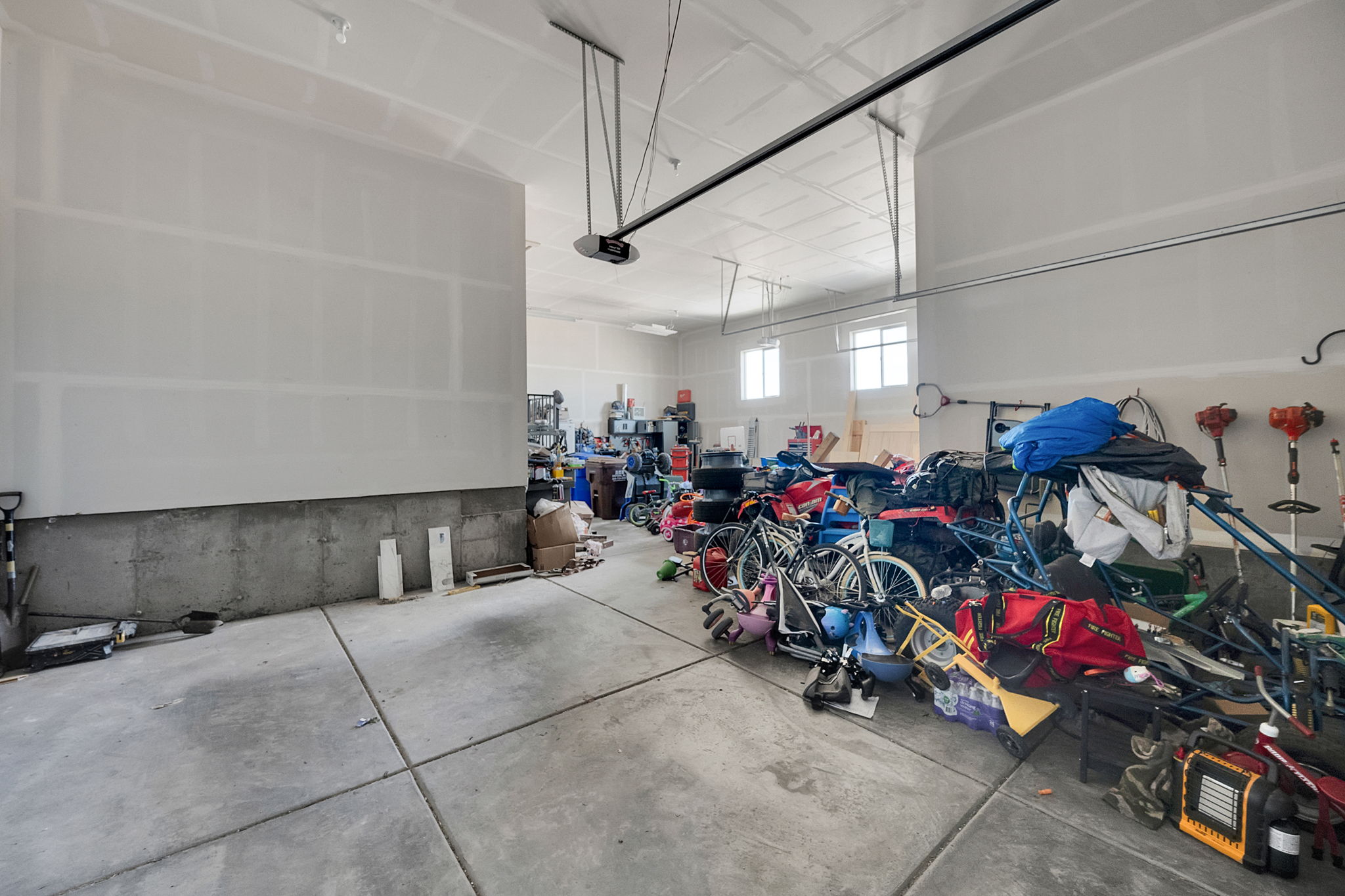 Spacious garage featuring a concrete floor, high ceilings, and windows providing natural light