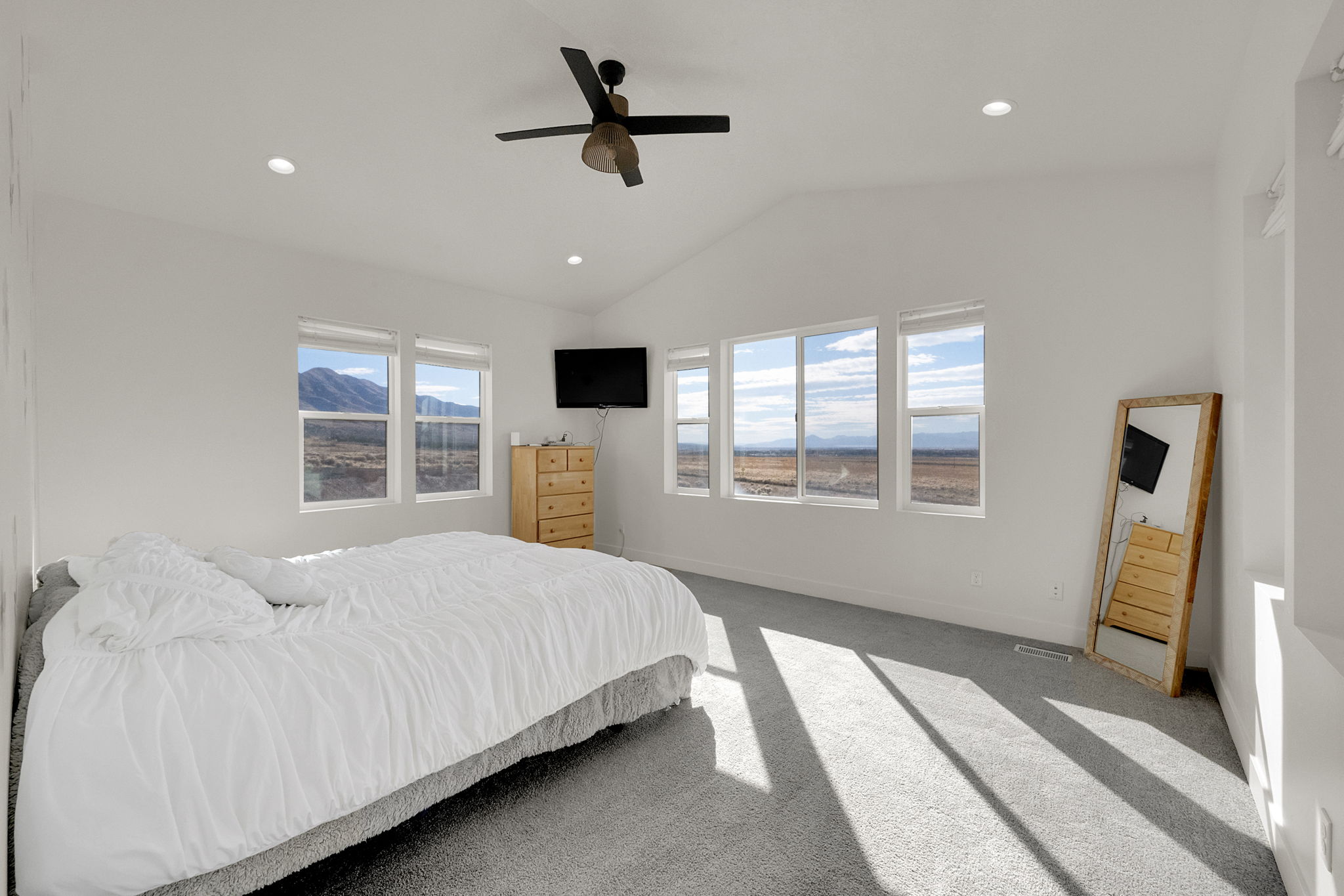 Spacious room featuring vaulted ceilings, a contemporary ceiling fan, and recessed lighting