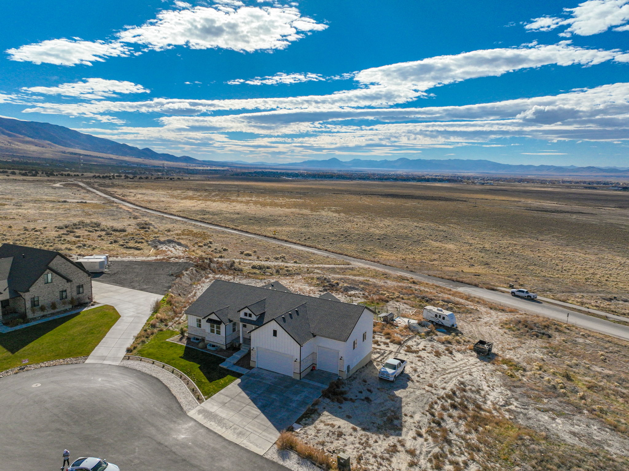 Modern farmhouse-style residence featuring a prominent two-car garage, dark shingle roofing, and a concrete driveway
