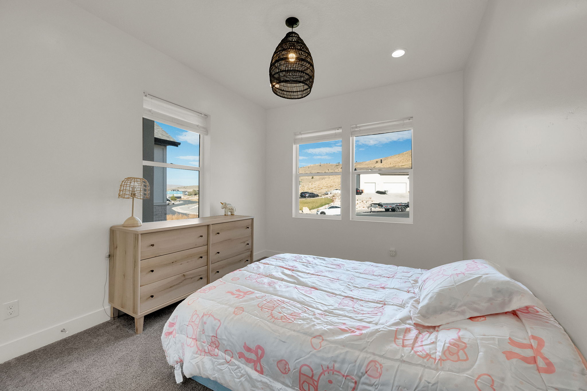 Bright room featuring two large windows, white walls, recessed lighting, and a modern pendant light fixture