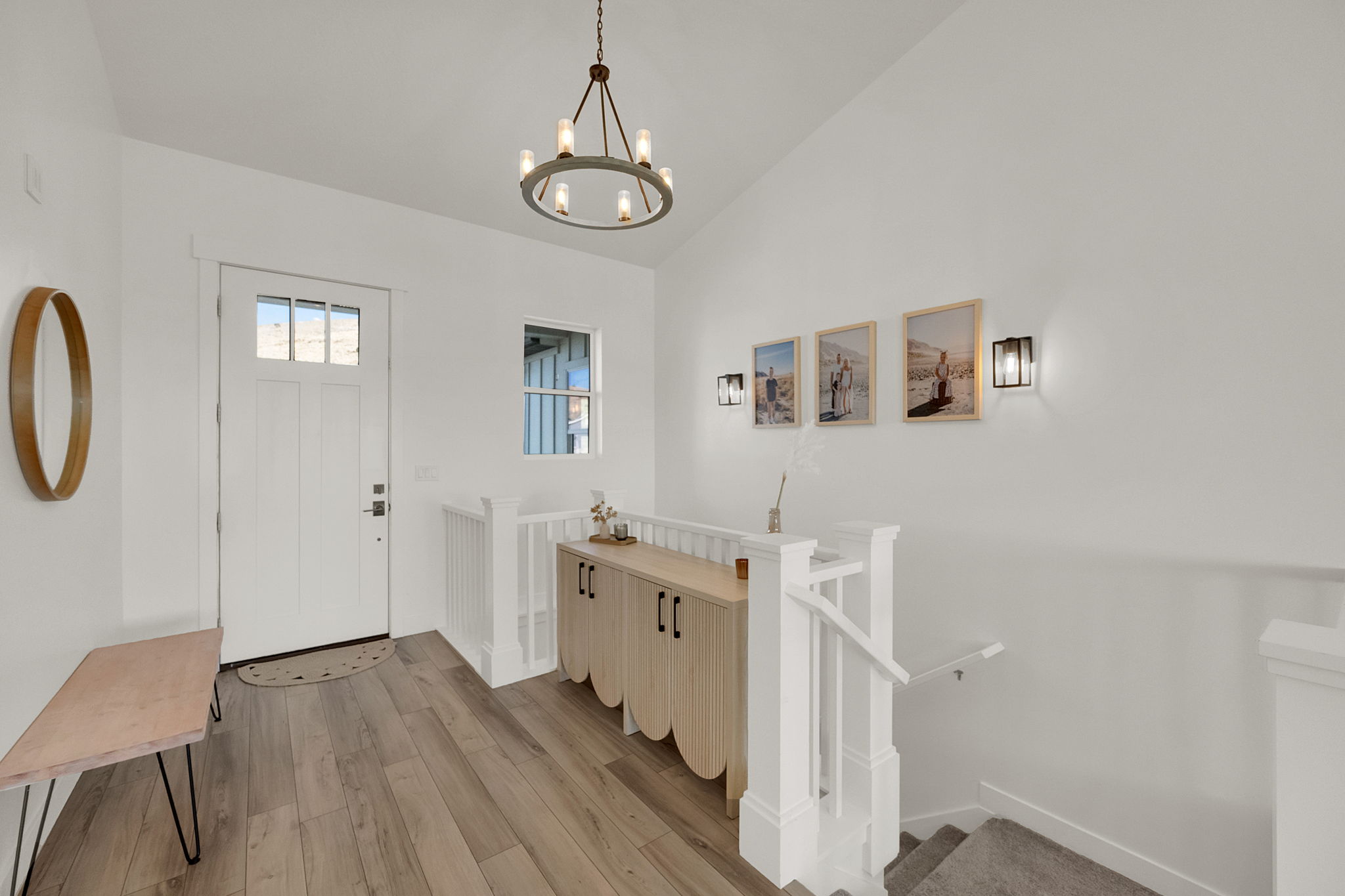 Bright entry foyer with wood-finish flooring and a contemporary chandelier