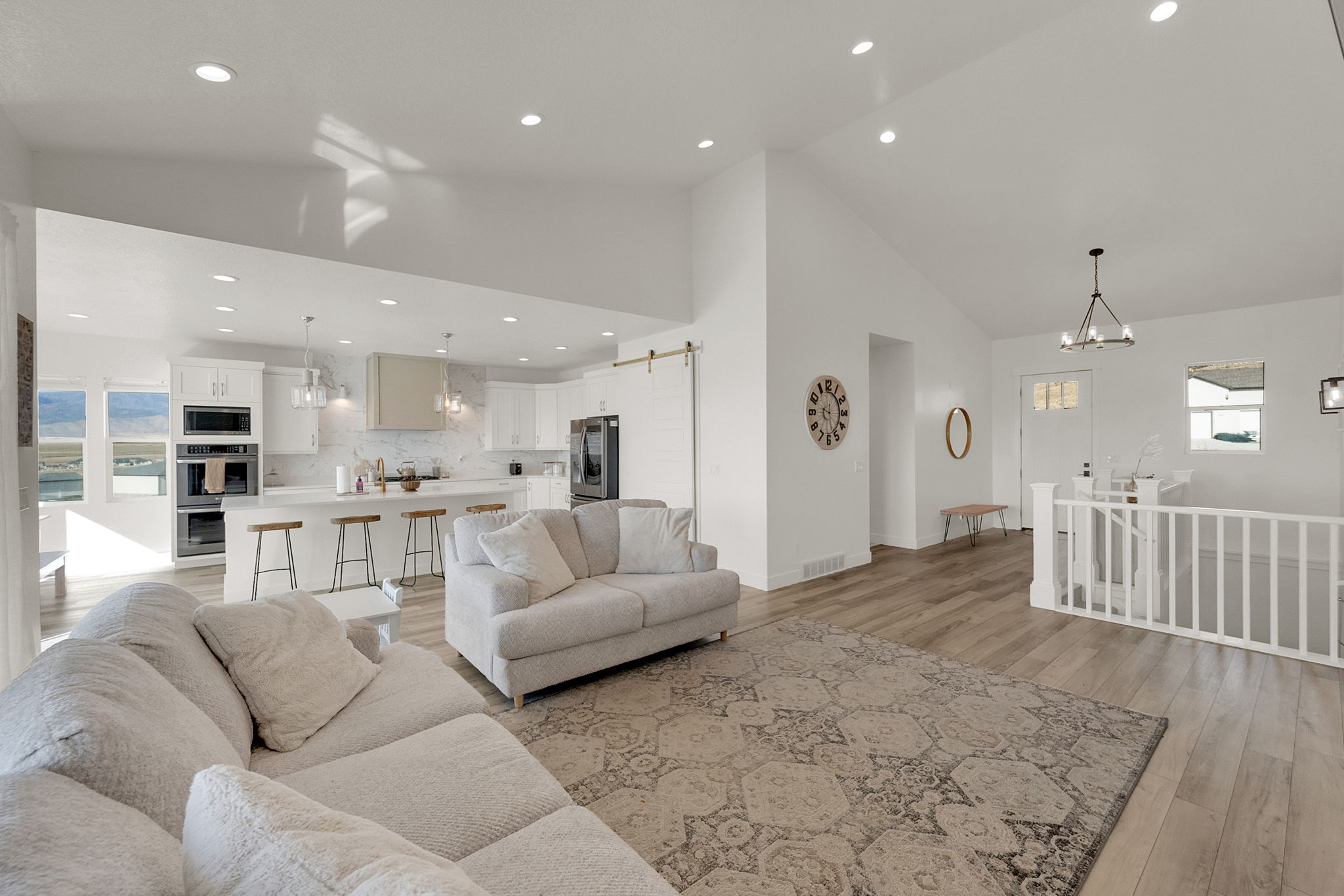 Expansive open-concept living area featuring a vaulted ceiling and wood-finish flooring