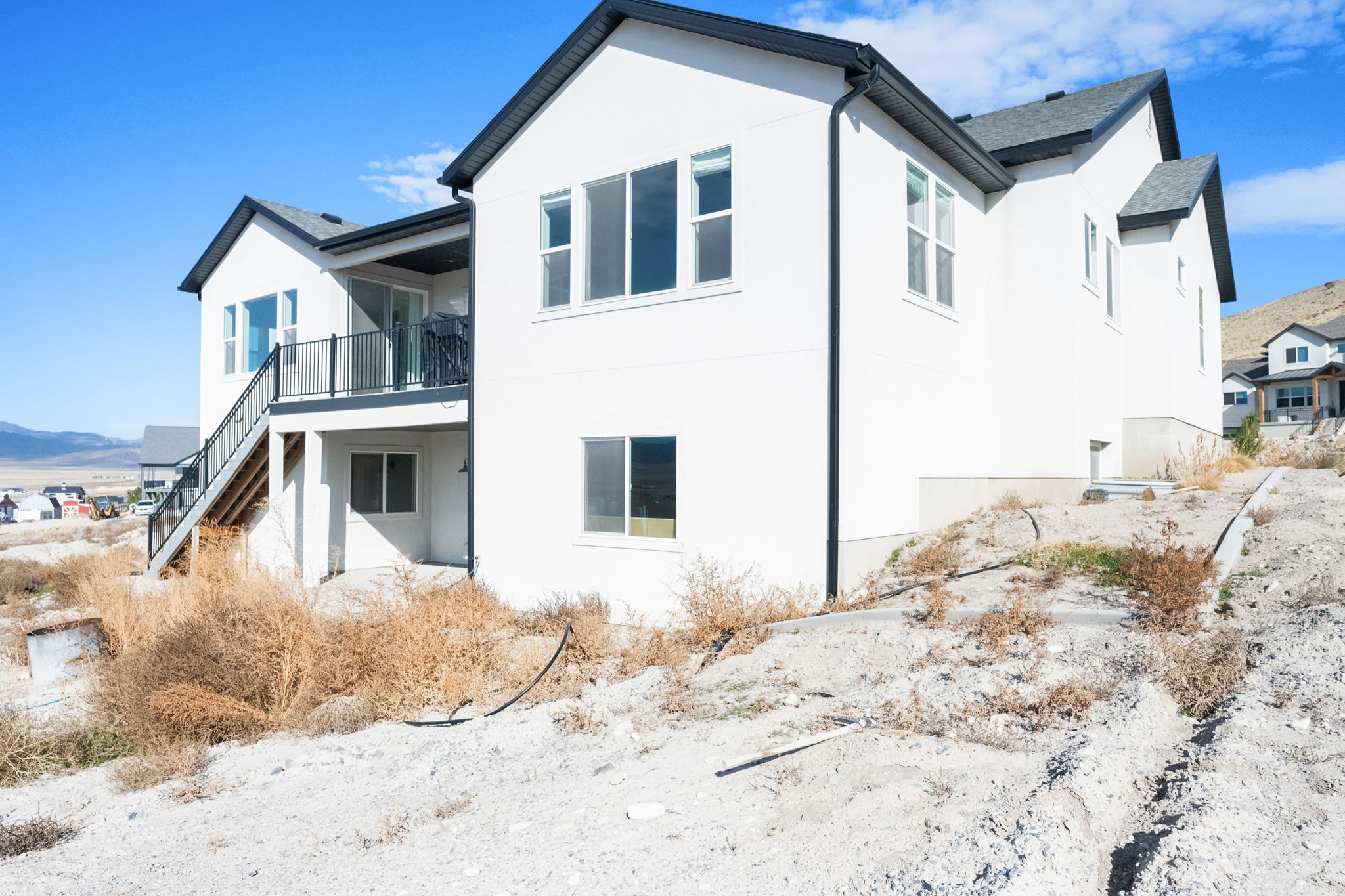 Contemporary two-story residence featuring a clean white exterior and dark roofline