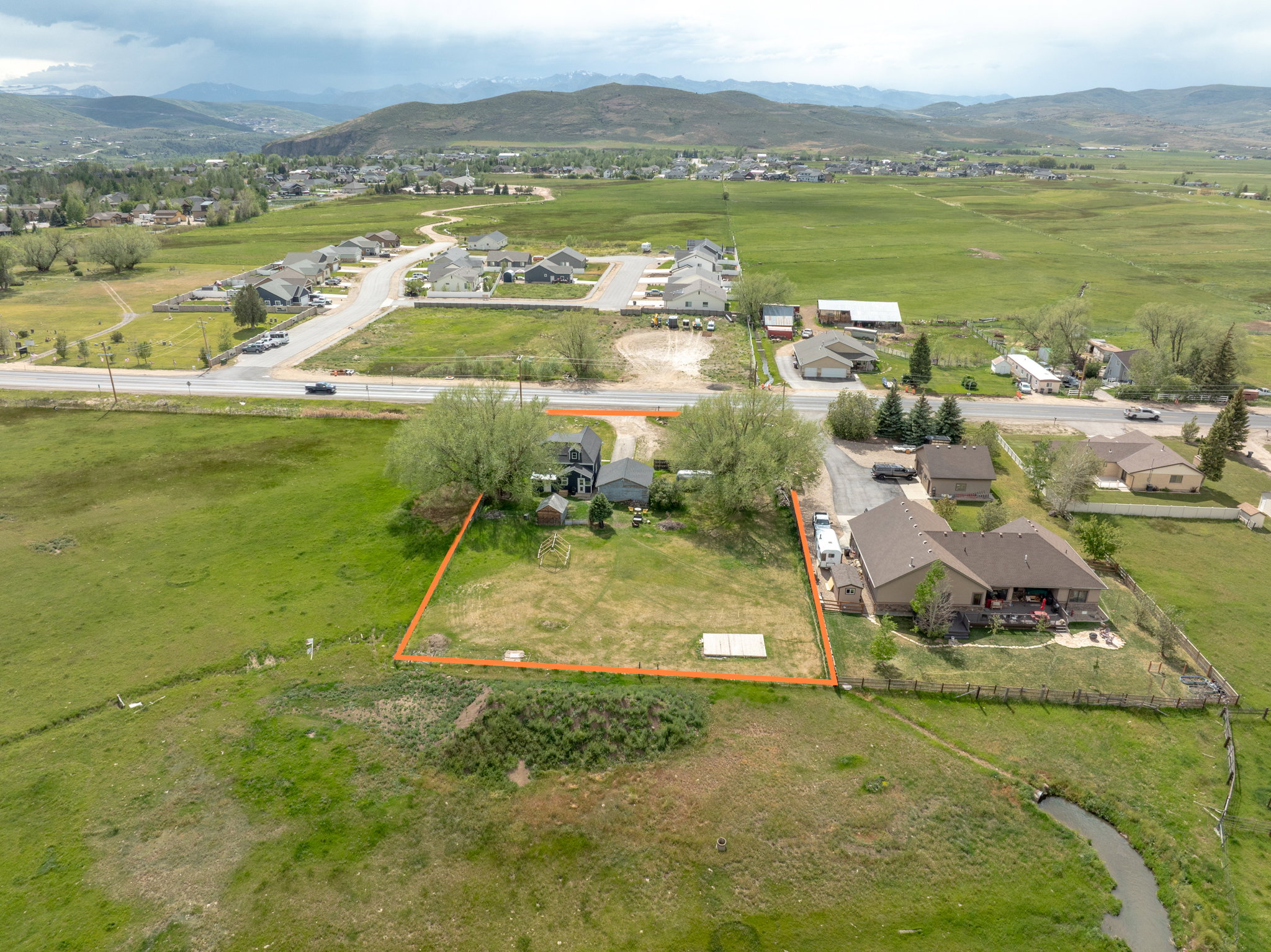 Expansive green lot with established trees and a defined boundary