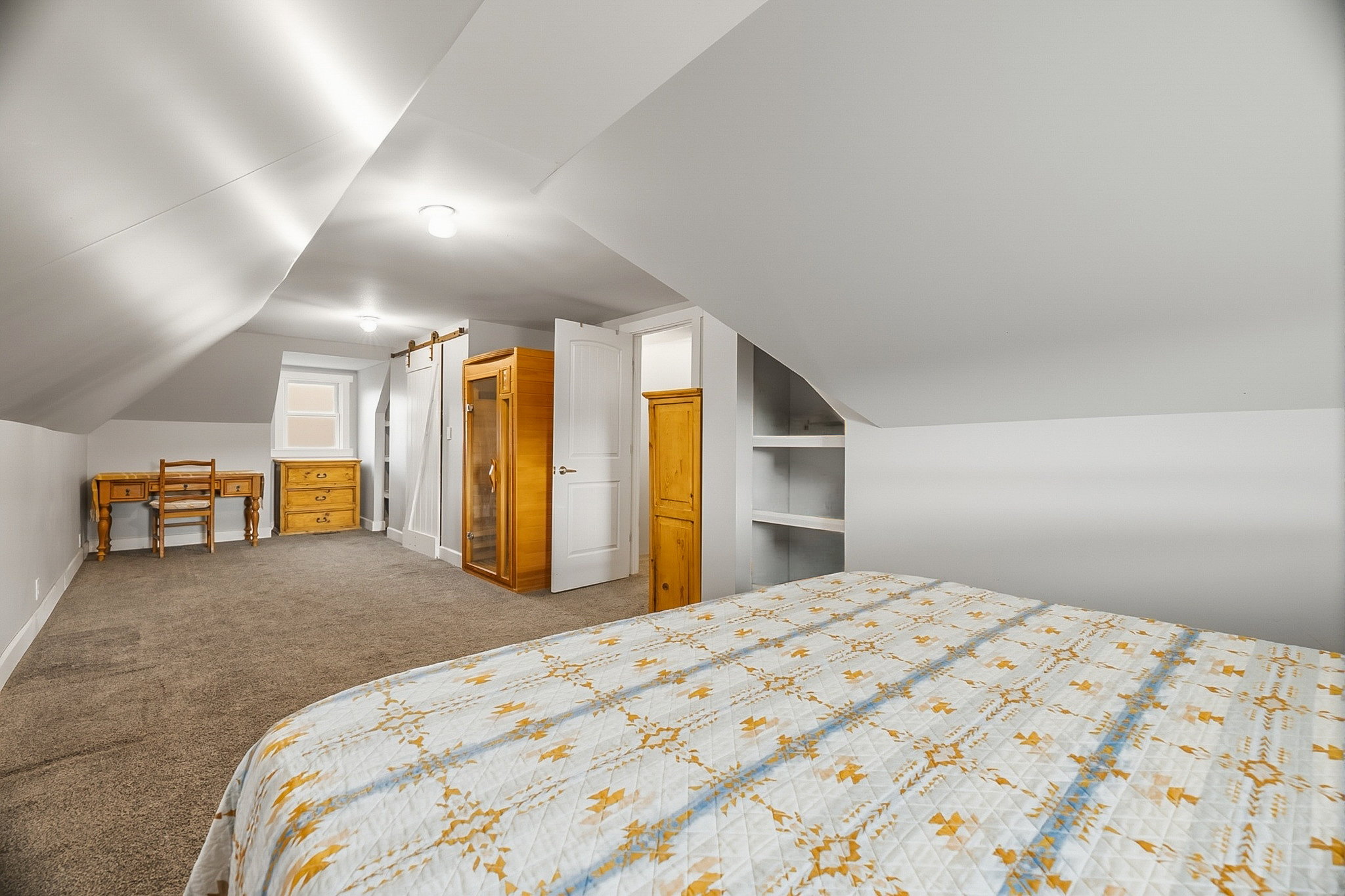Carpeted room with sloped ceilings and recessed lighting
