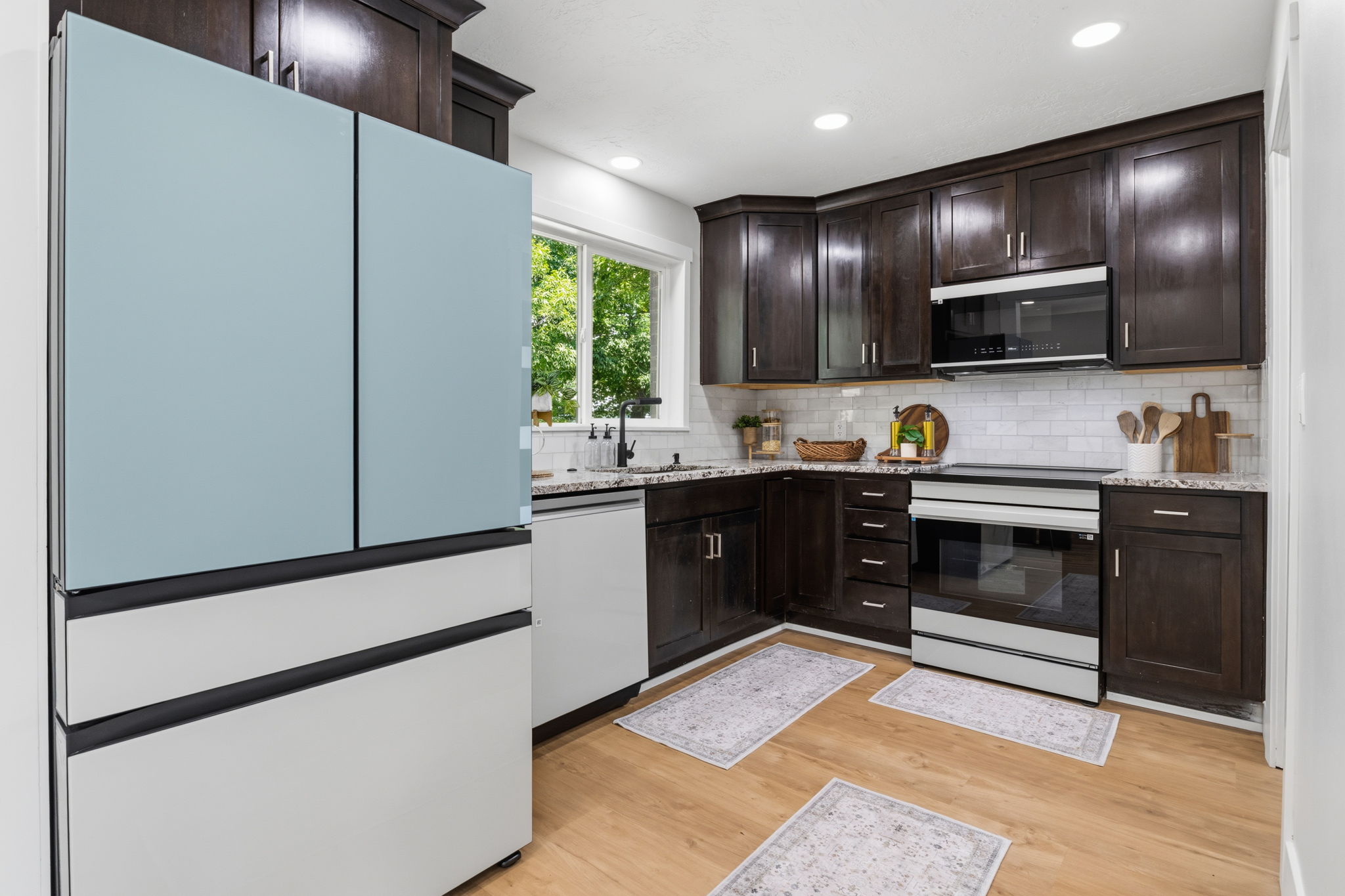 Main Kitchen featuring dark wood cabinetry, light wood-finish flooring, and white subway tile backsplash
