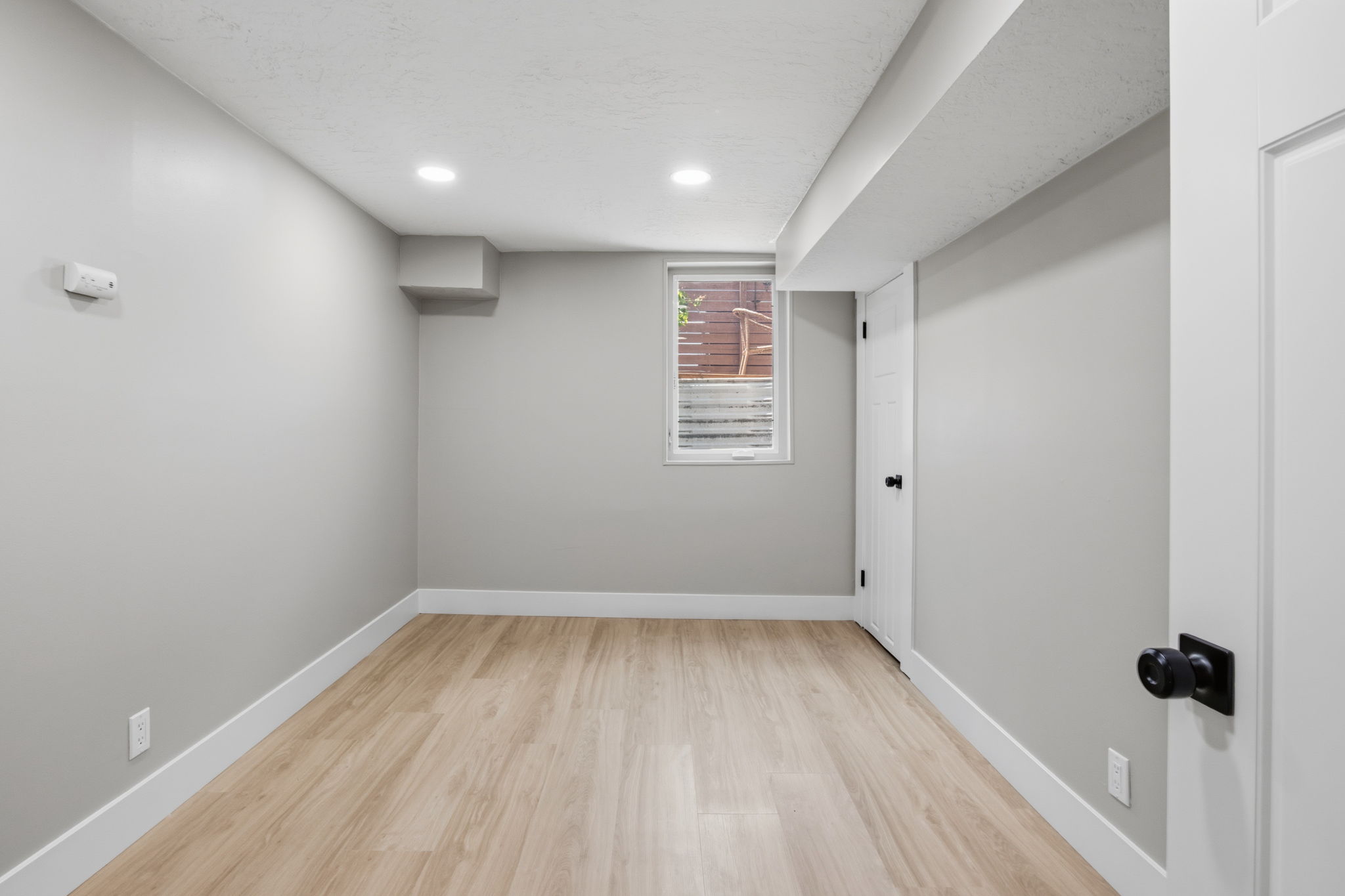 Room featuring neutral painted walls, light wood-finish flooring, recessed lighting, and white baseboards