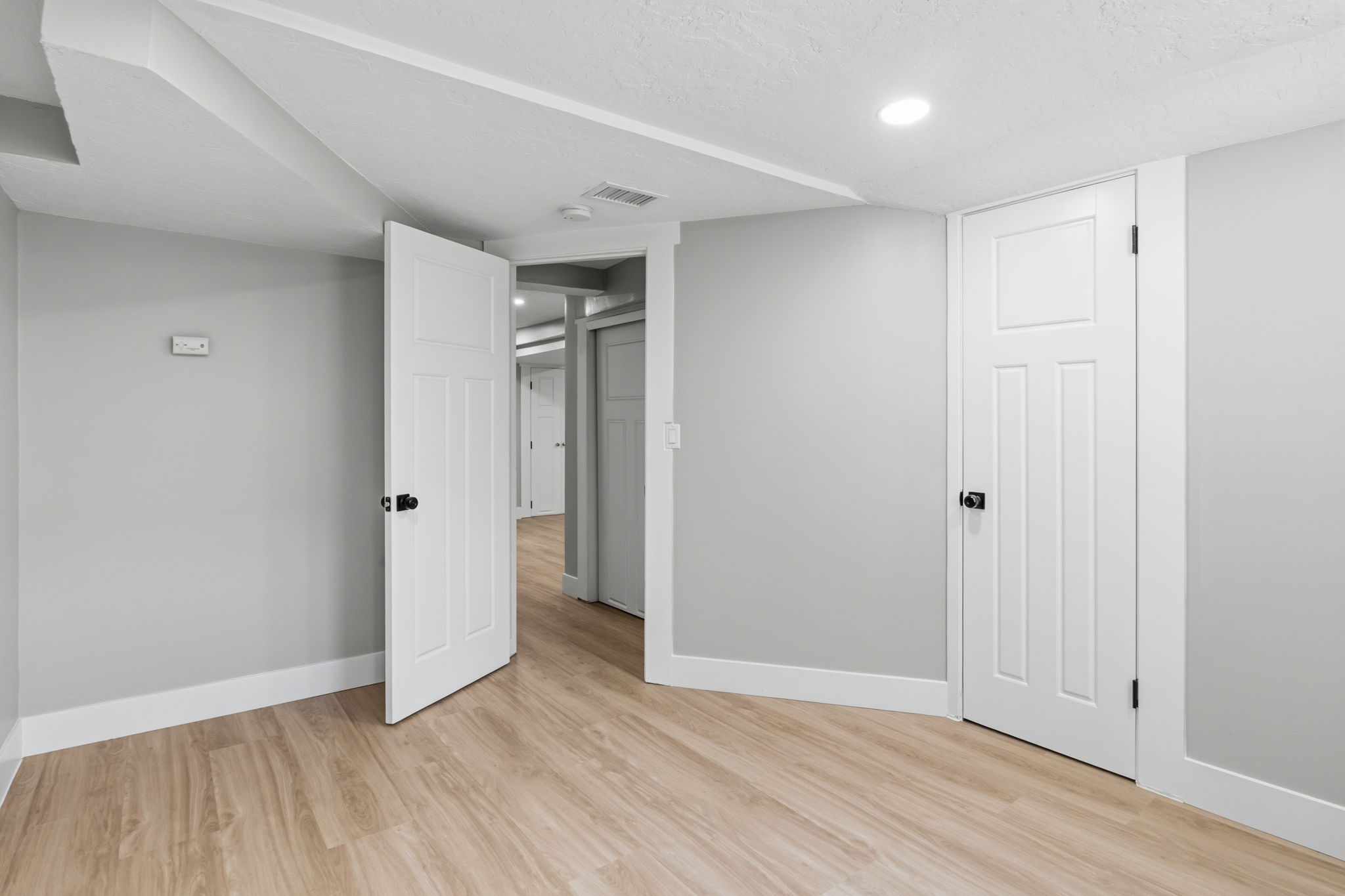 Interior room featuring light wood-finish flooring, white trim, and light gray walls