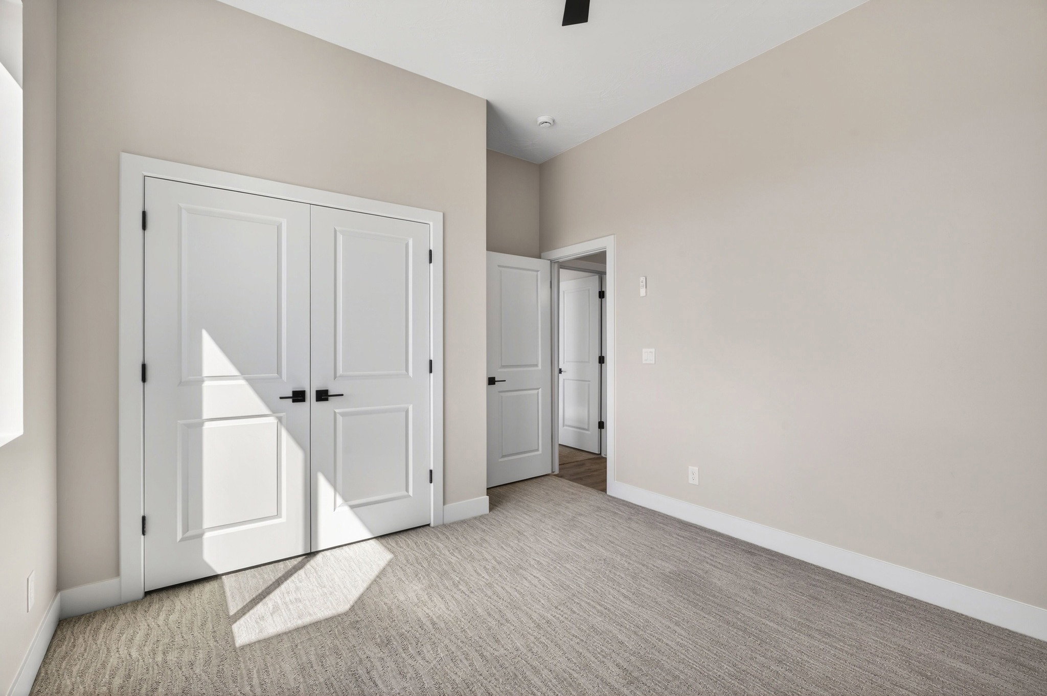 Neutral toned room featuring a textured carpet and light-colored walls