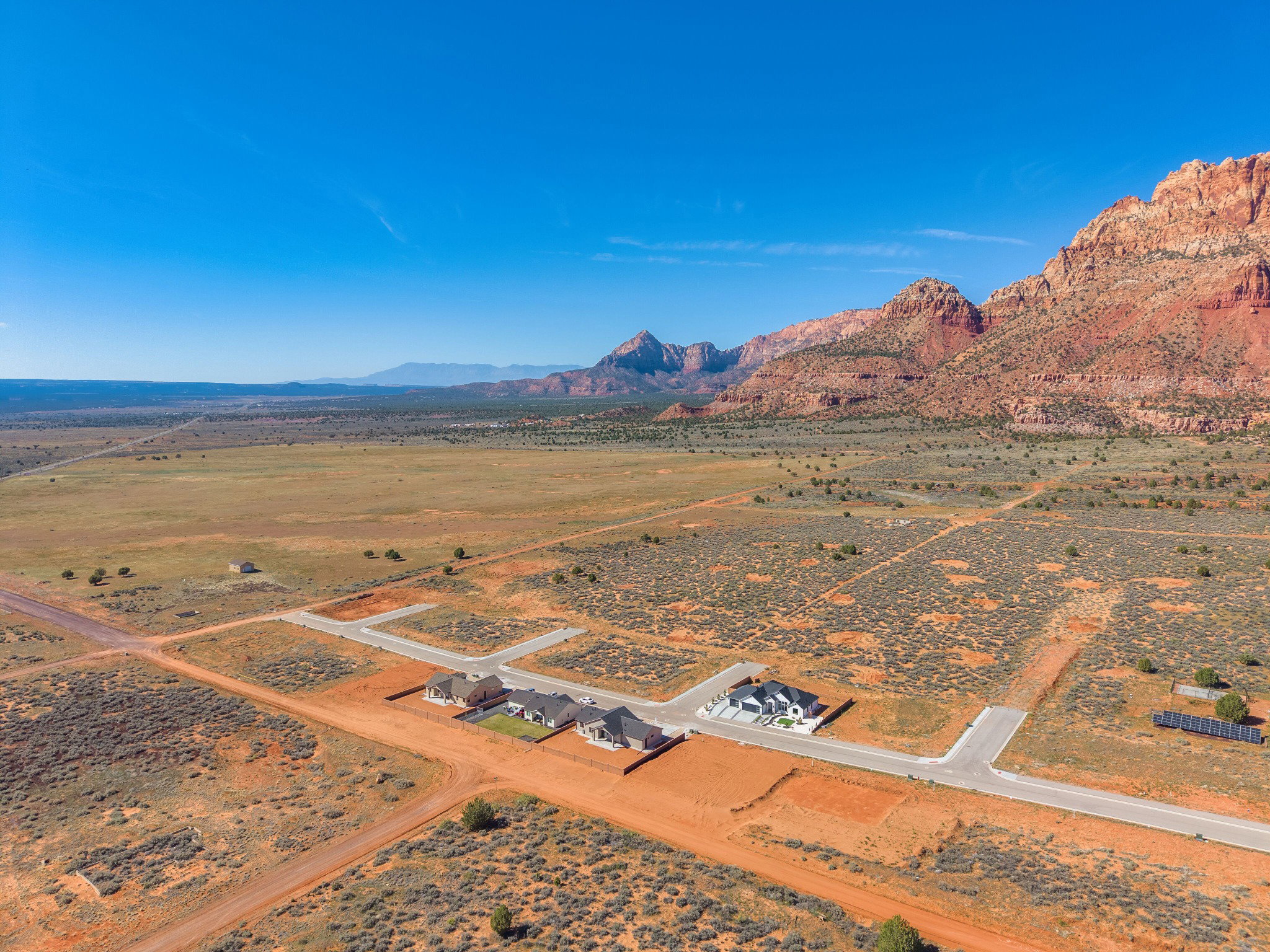 Aerial perspective showcasing multiple properties and building lots with a mountain backdrop