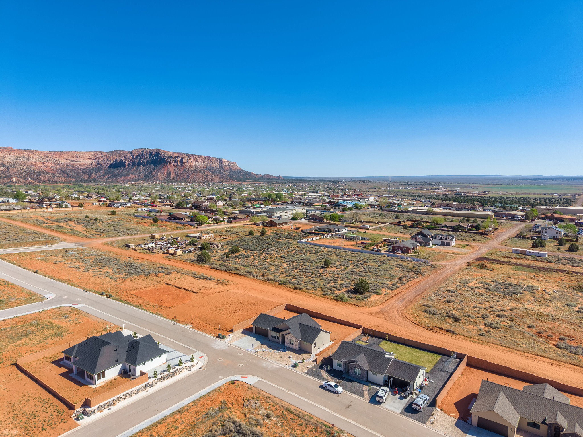 Aerial perspective of a developing residential area with paved streets and established homes