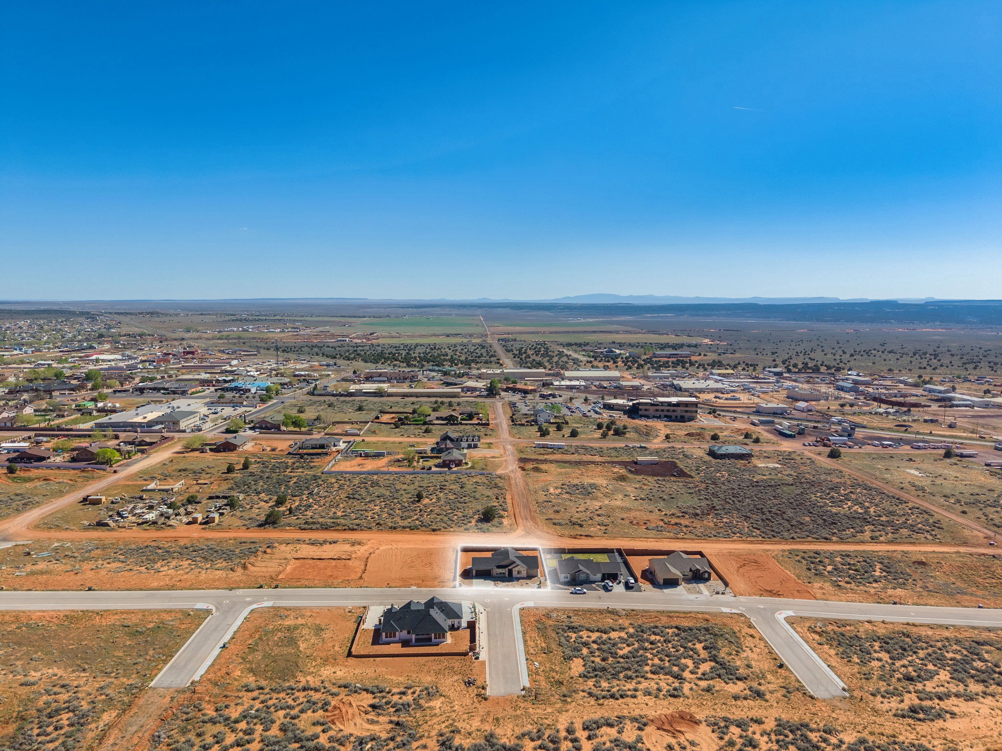 New construction homes situated on generous land parcels within a developing neighborhood, featuring paved street access