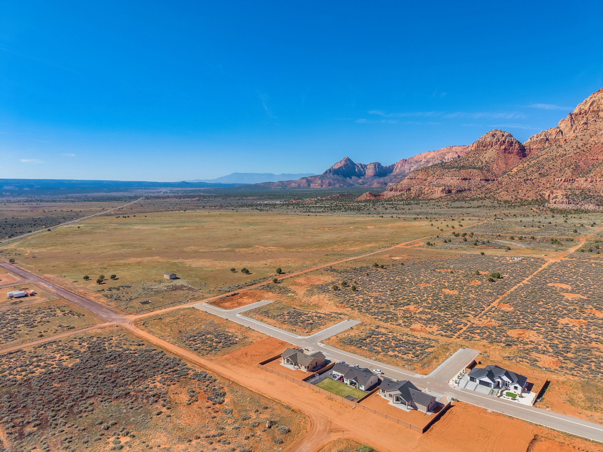 Expansive desert landscape featuring red rock mountains in the background