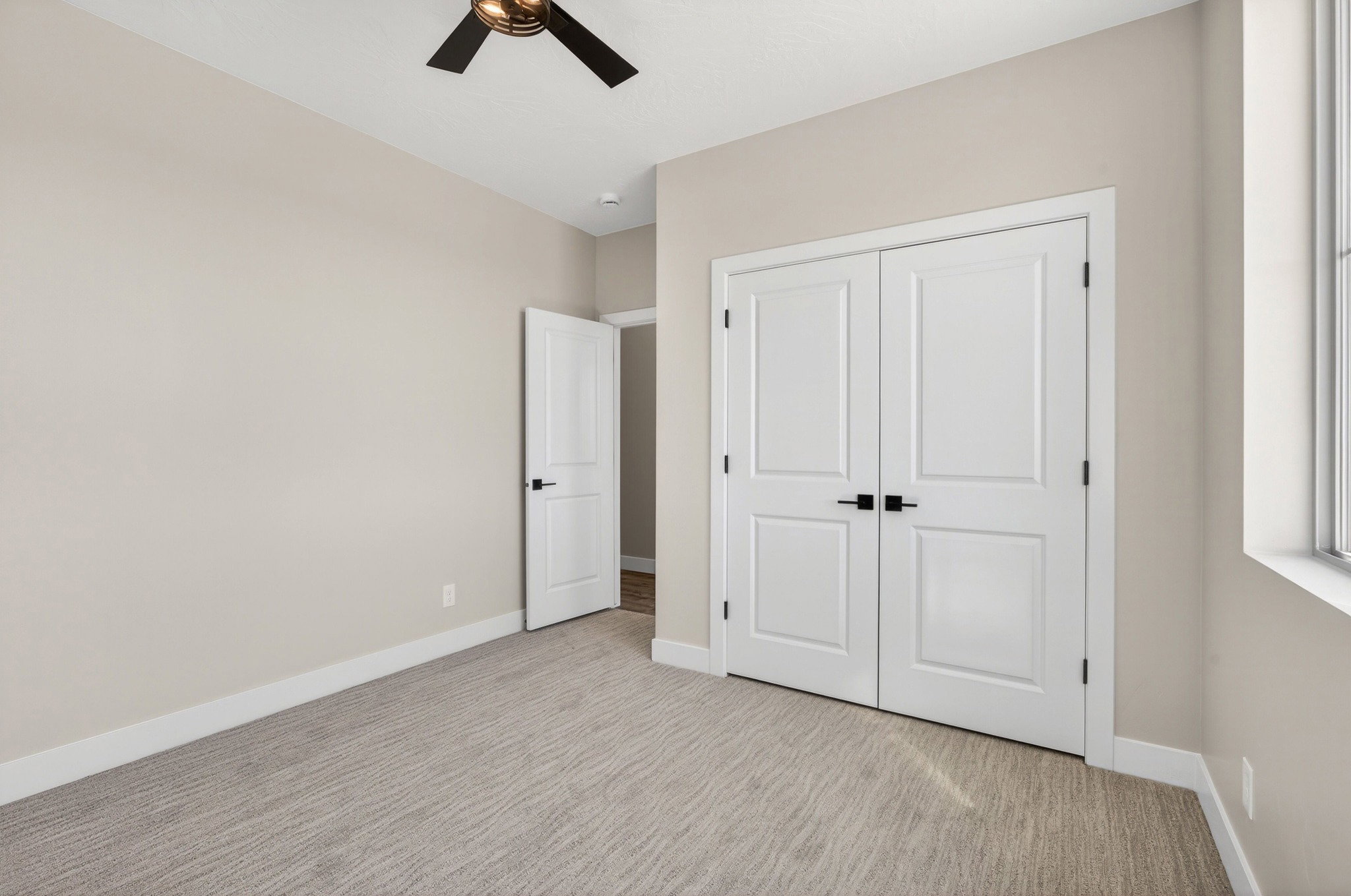 Room featuring neutral wall tones, patterned carpet flooring, white trim, and a multi-pane window