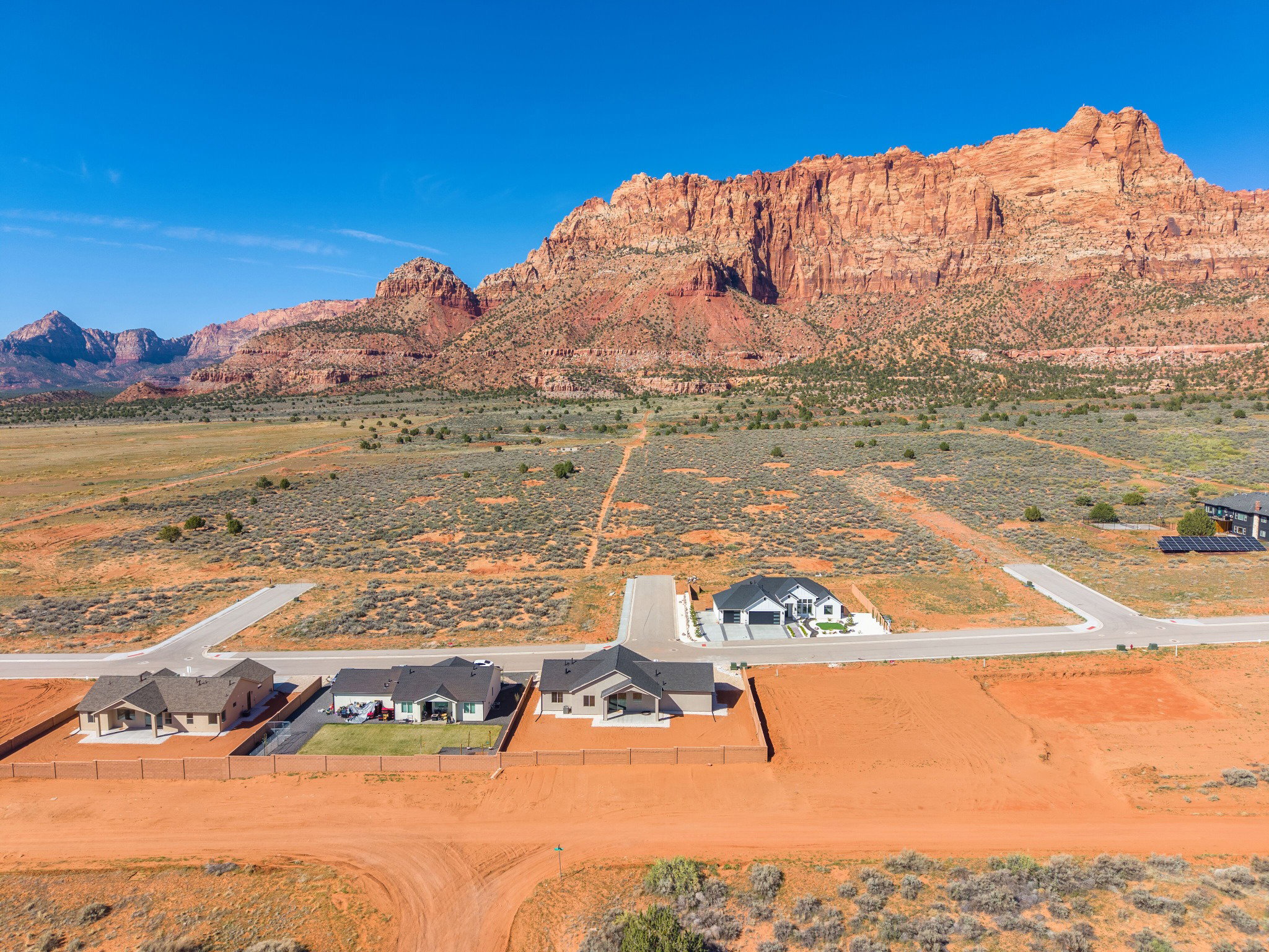 Expansive residential development featuring multiple single-story homes and undeveloped land parcels
