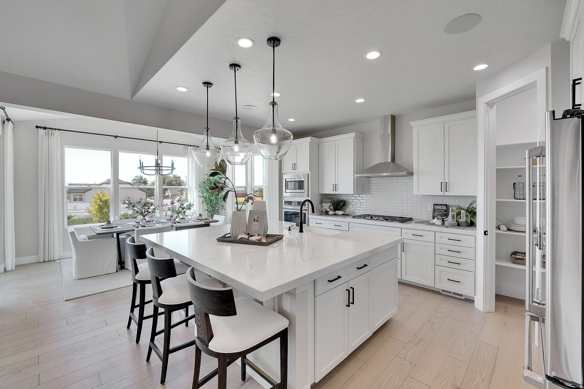 Kitchen featuring a central island with countertop seating, white shaker cabinetry, stainless steel appliances, and a subway tile backsplash
