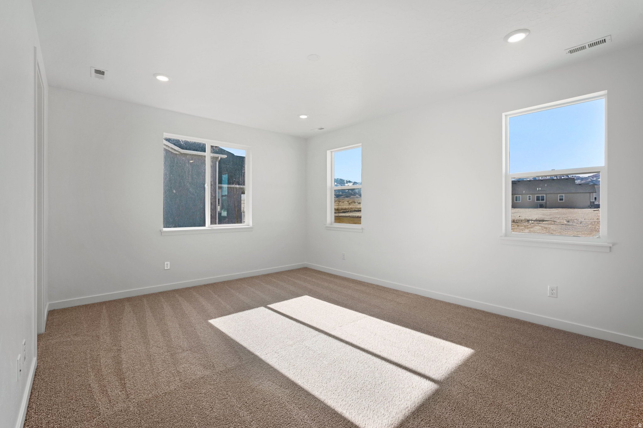 Bright interior space featuring light beige carpet