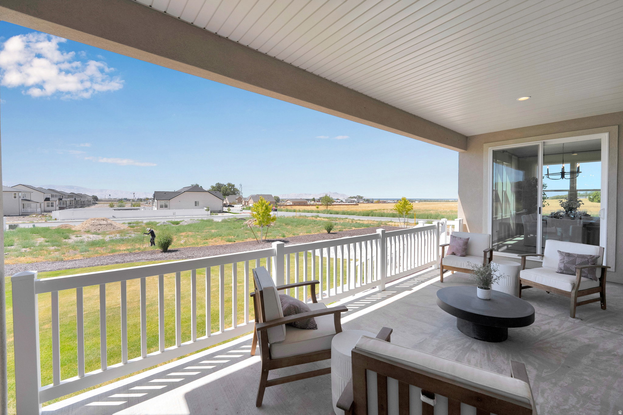 Covered patio featuring concrete flooring and a white railing