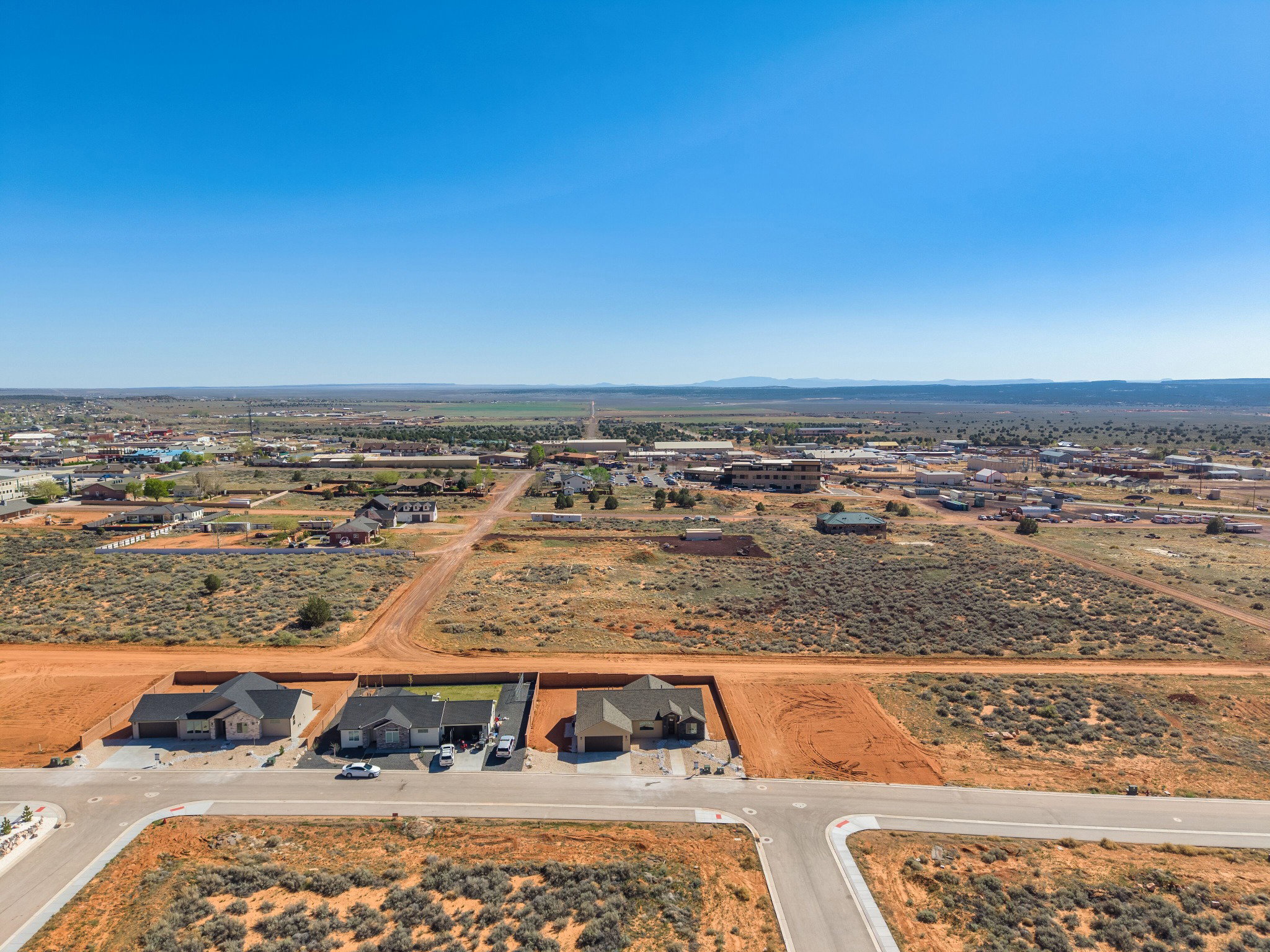 Aerial perspective showcasing a developing residential area with paved streets and established homes